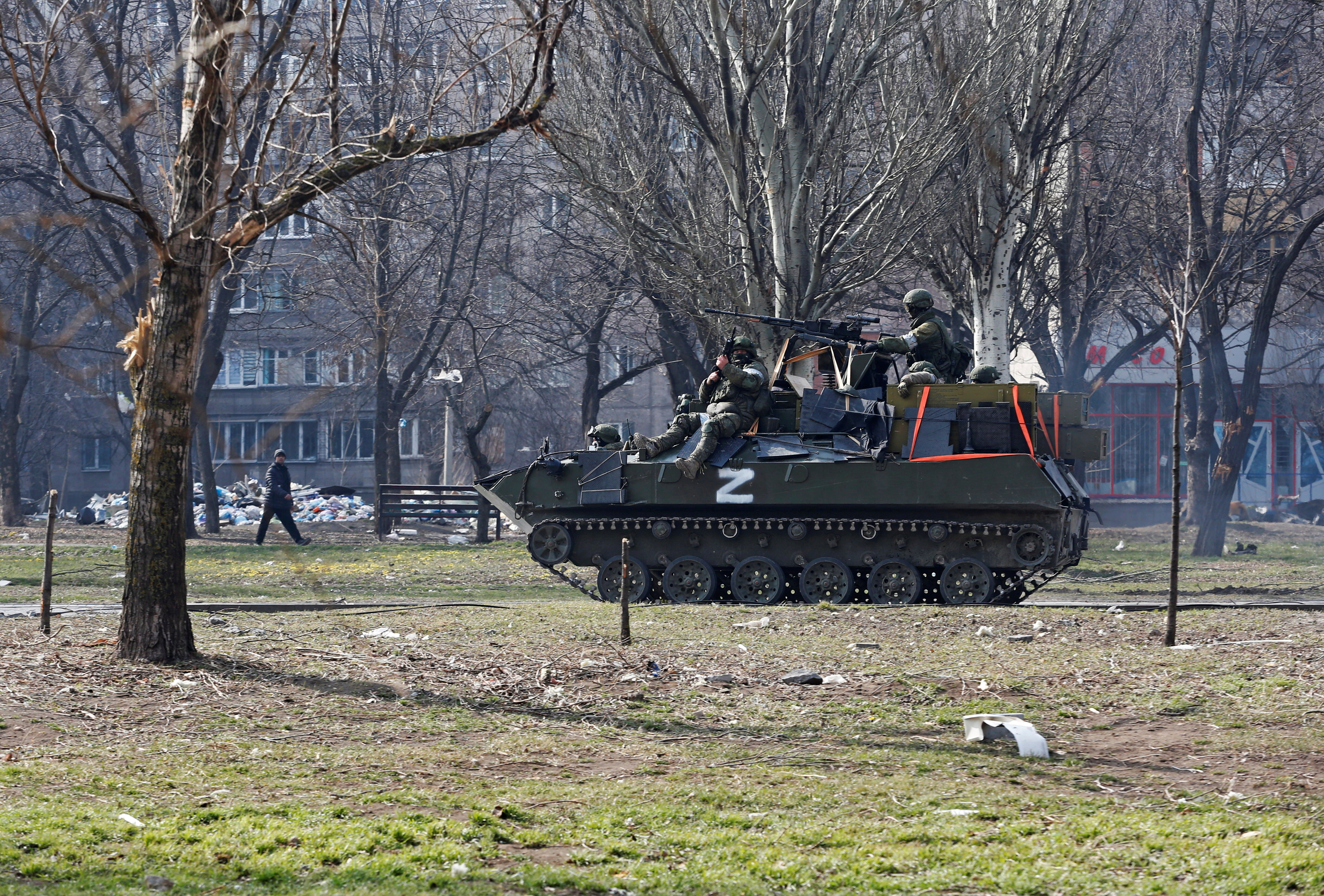 Service members of pro-Russian troops are seen atop of an armoured vehicle in Mariupol