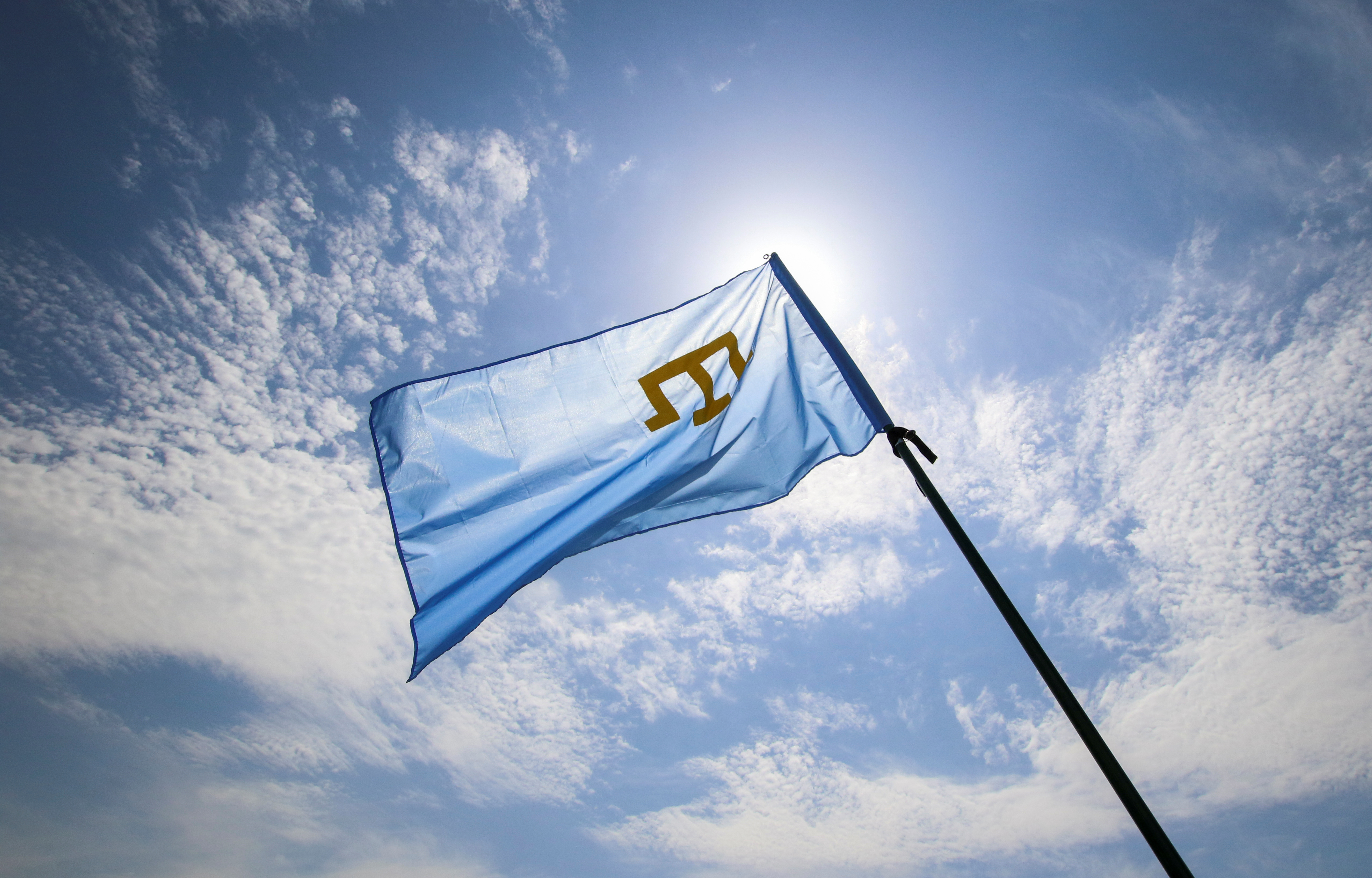 A Crimean Tatars flag flies at a rally, commemorating Crimean Tatars mass deportations from the region in 1944, in the village of Siren