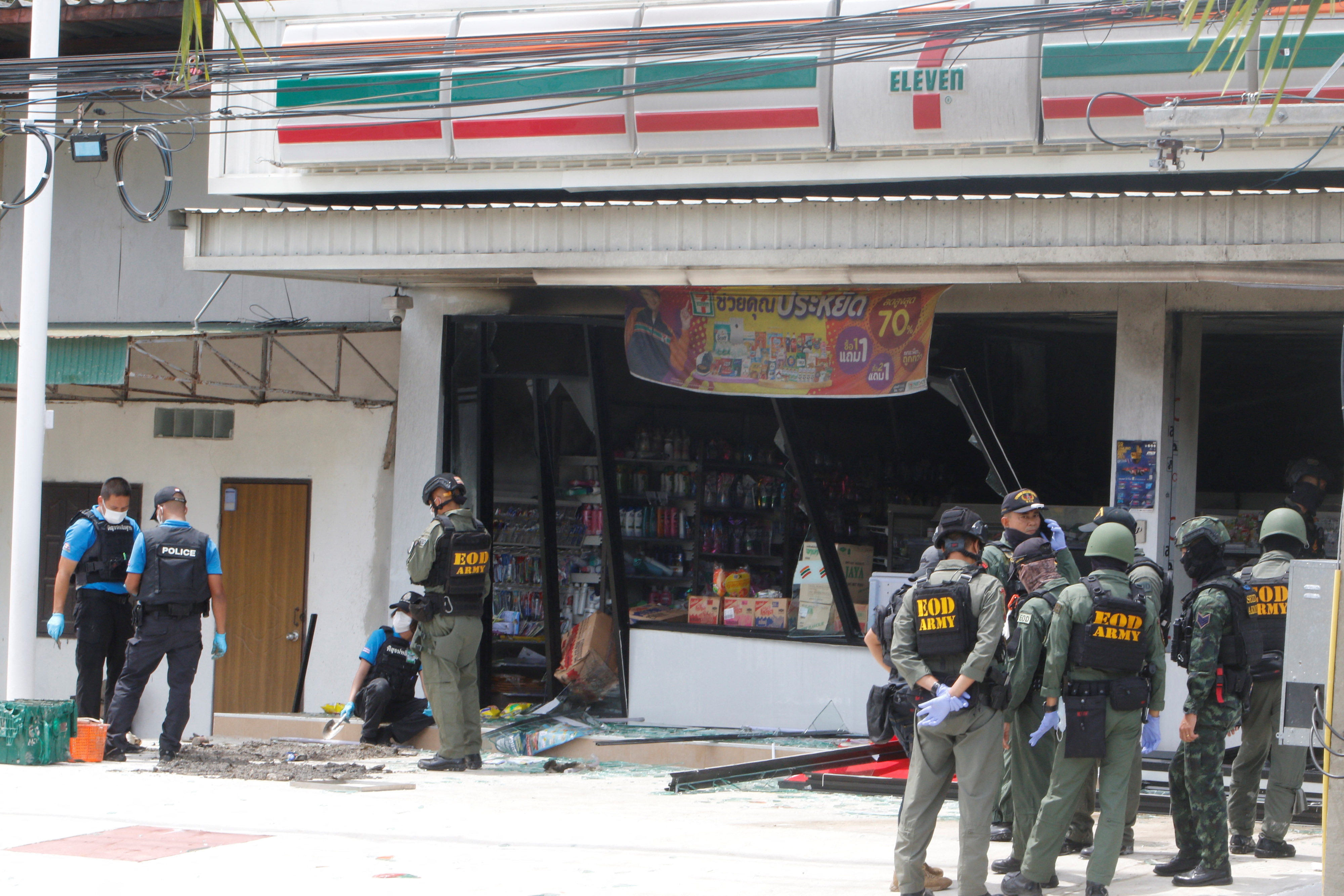 Emergency service members work in front of a shop after an explosion in Yala
