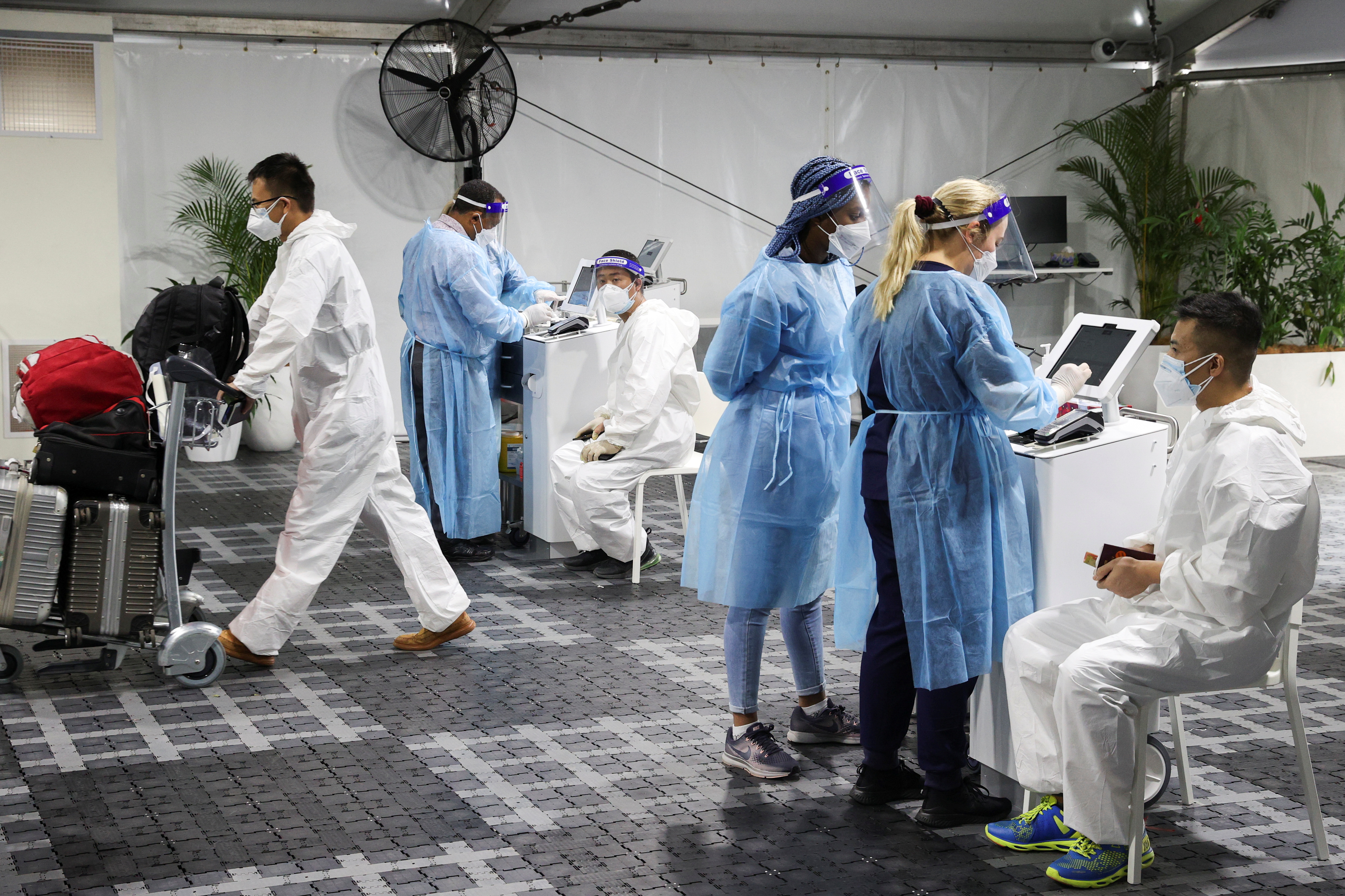 Travellers receive tests for the coronavirus disease (COVID-19) at a pre-departure testing facility, as countries react to the new coronavirus Omicron variant, outside the international terminal at Sydney Airport in Sydney, Australia, November 29, 2021.  REUTERS/Loren Elliott
