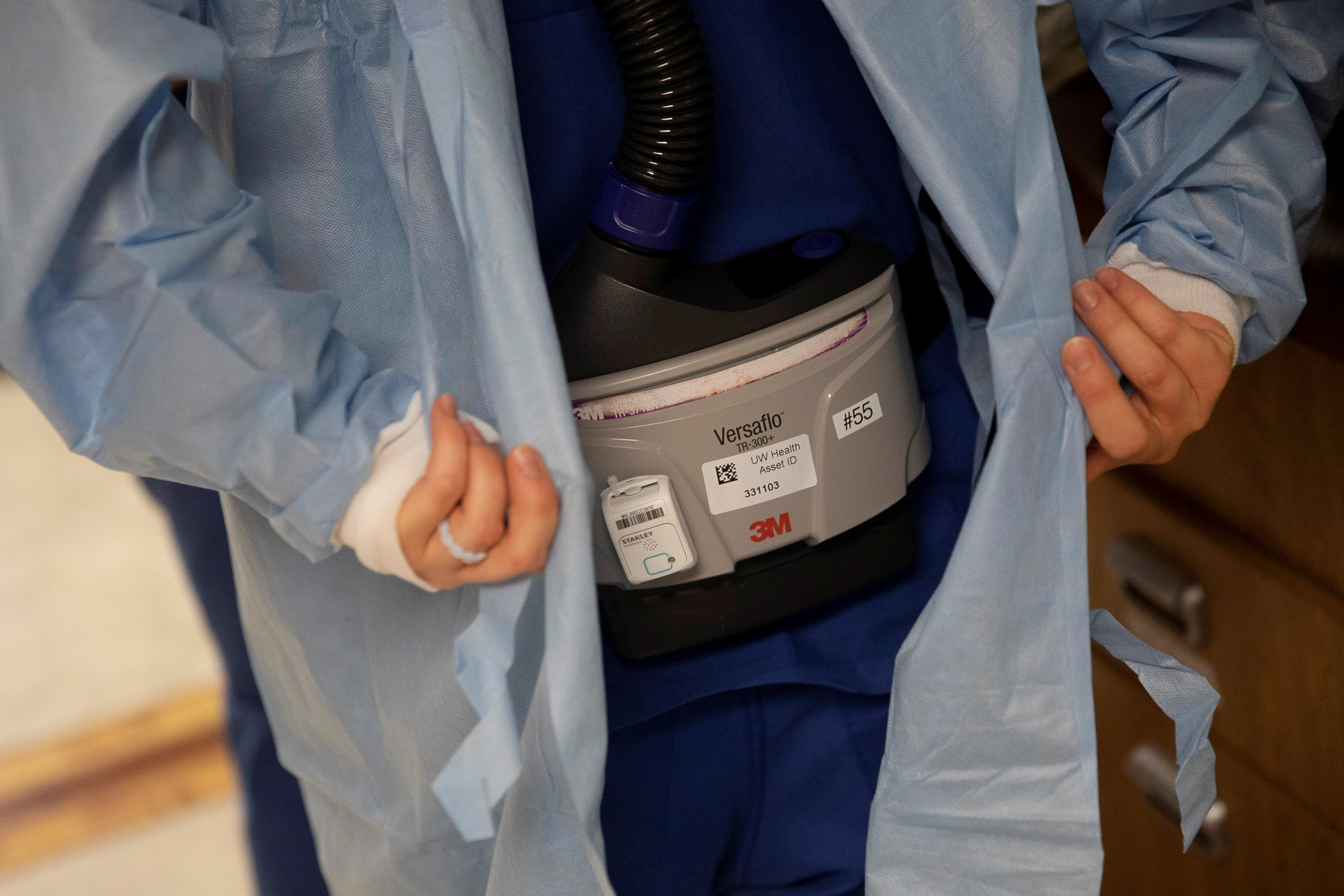 Nursing Assistant Brittany Digman wears a 3M Versaflo TR-300+ powered air purifying respirator as she prepares to enter the room of a coronavirus disease (COVID-19) patient being treated at UW Health University Hospital in Madison, Wisconsin, U.S. November 18, 2020.  REUTERS/Daniel Acker