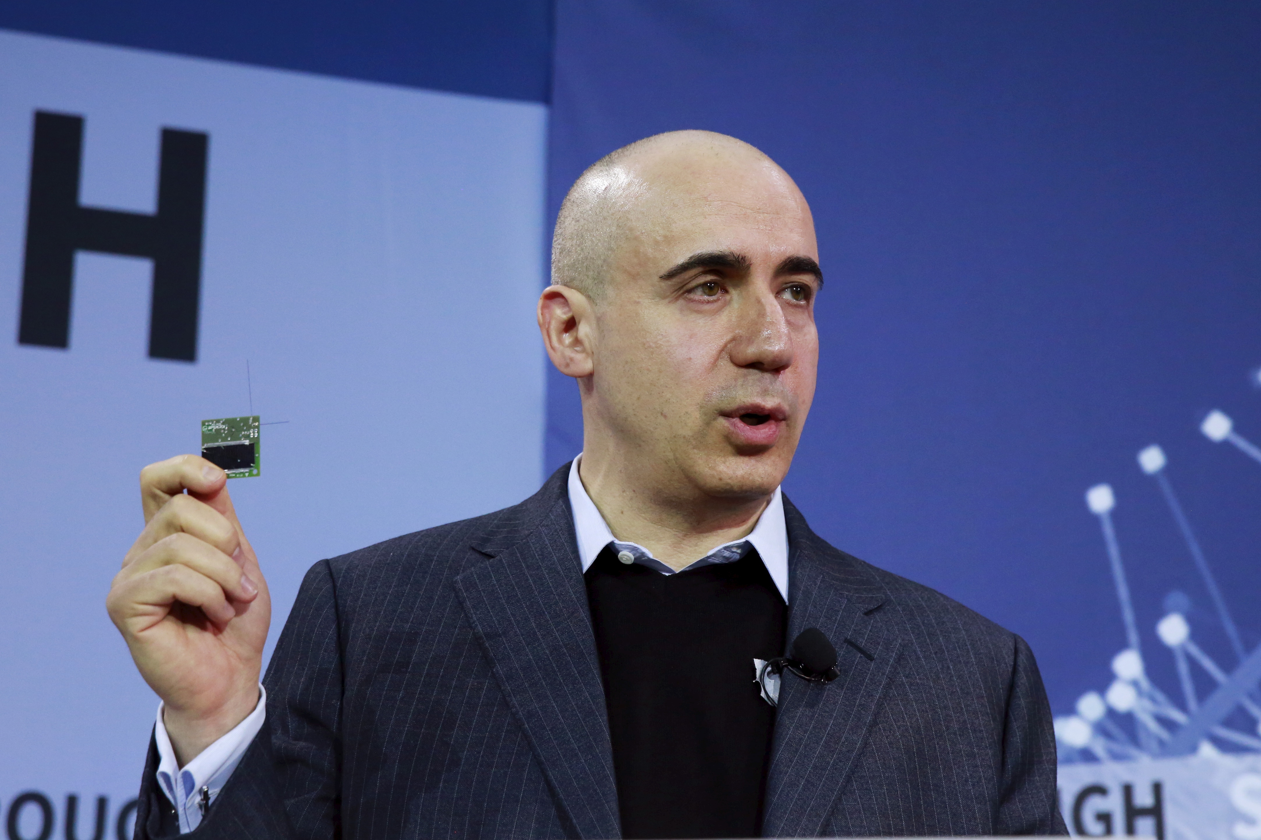 Investor Yuri Milner holds a small chip during an announcement of the Breakthrough Starshot initiative in New York