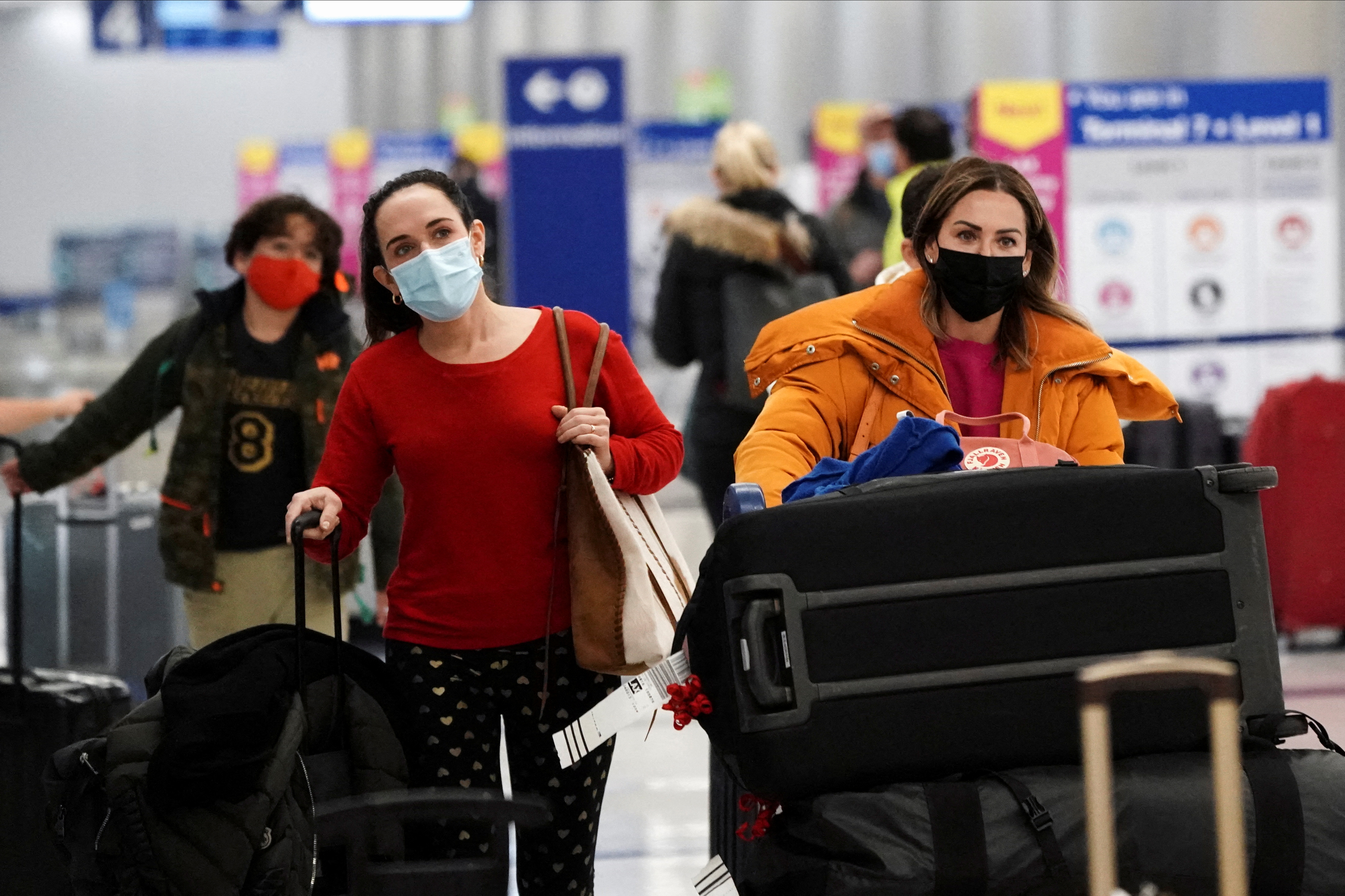 Travelers push their luggage past baggage claim inside the United Airlines terminal at Los Angeles International Airport (LAX) during the holiday season as the coronavirus disease (COVID-19) Omicron variant threatens to increase case numbers in Los Angeles, California, U.S. December 22, 2021. REUTERS/Bing Guan