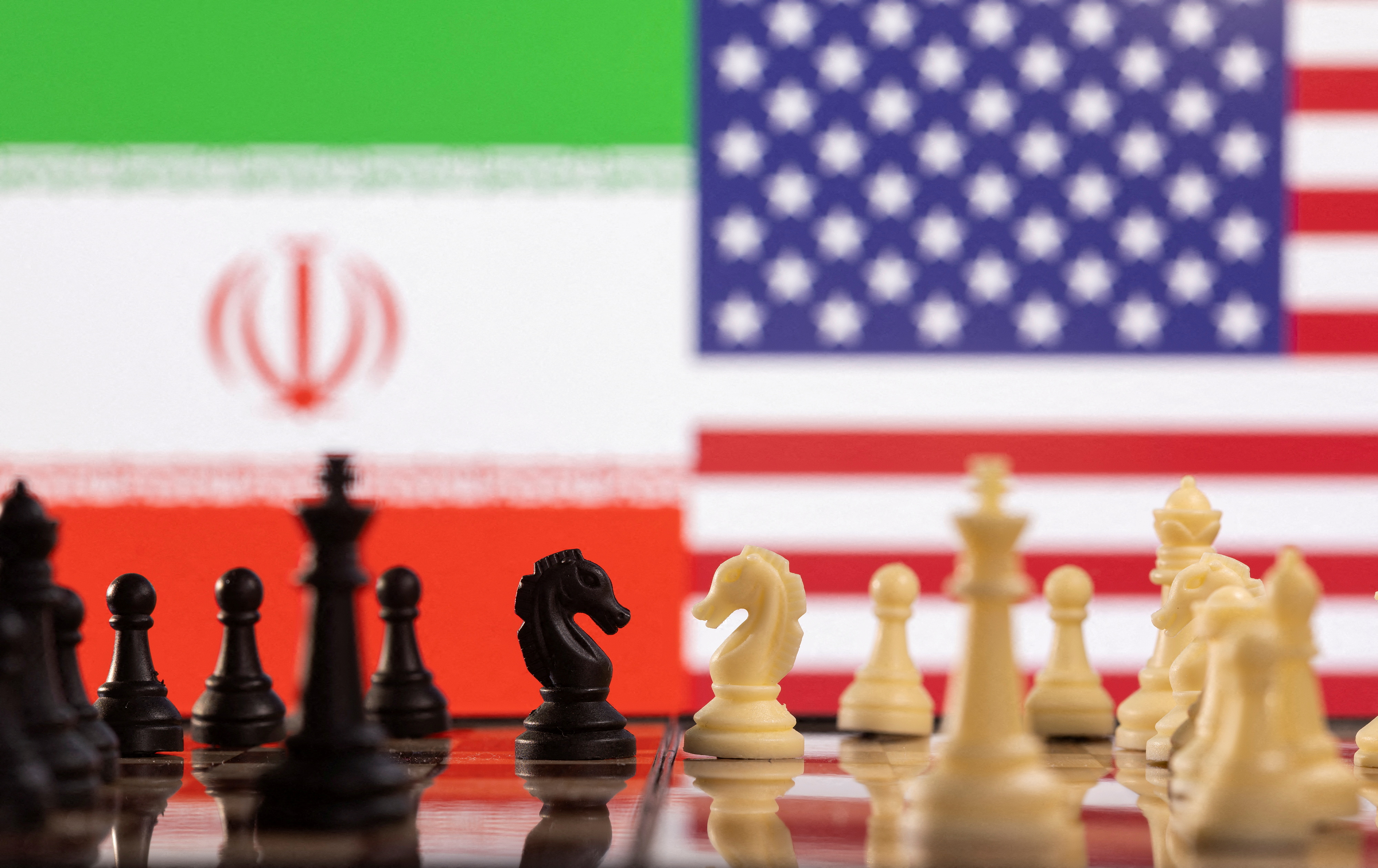 Chess pieces are seen in front of displayed Iran's and U.S. flags in this illustration taken January 25, 2022. REUTERS/Dado Ruvic/Illustration/
