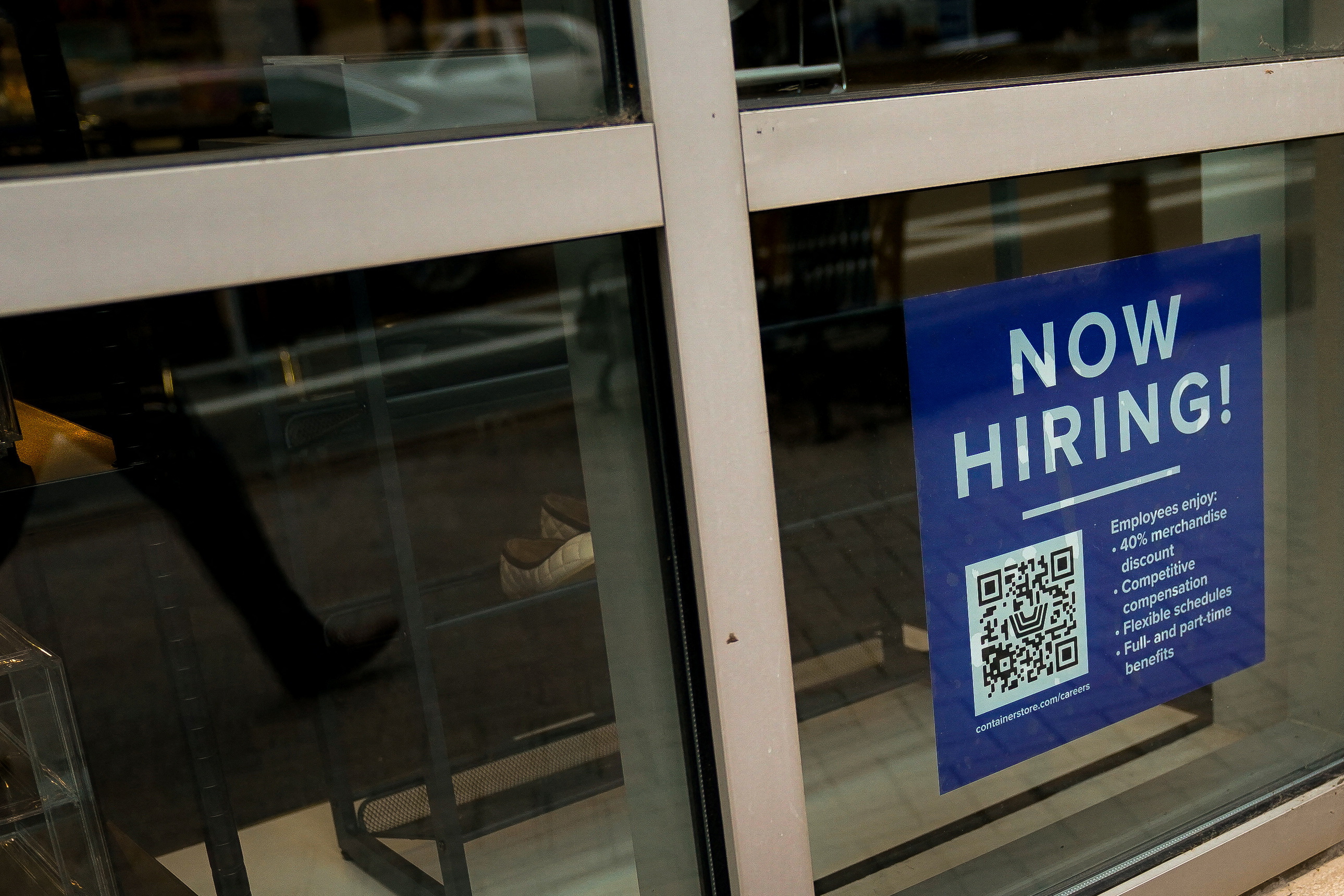 An employee employment sign with a QR code appears in an Arlington business window