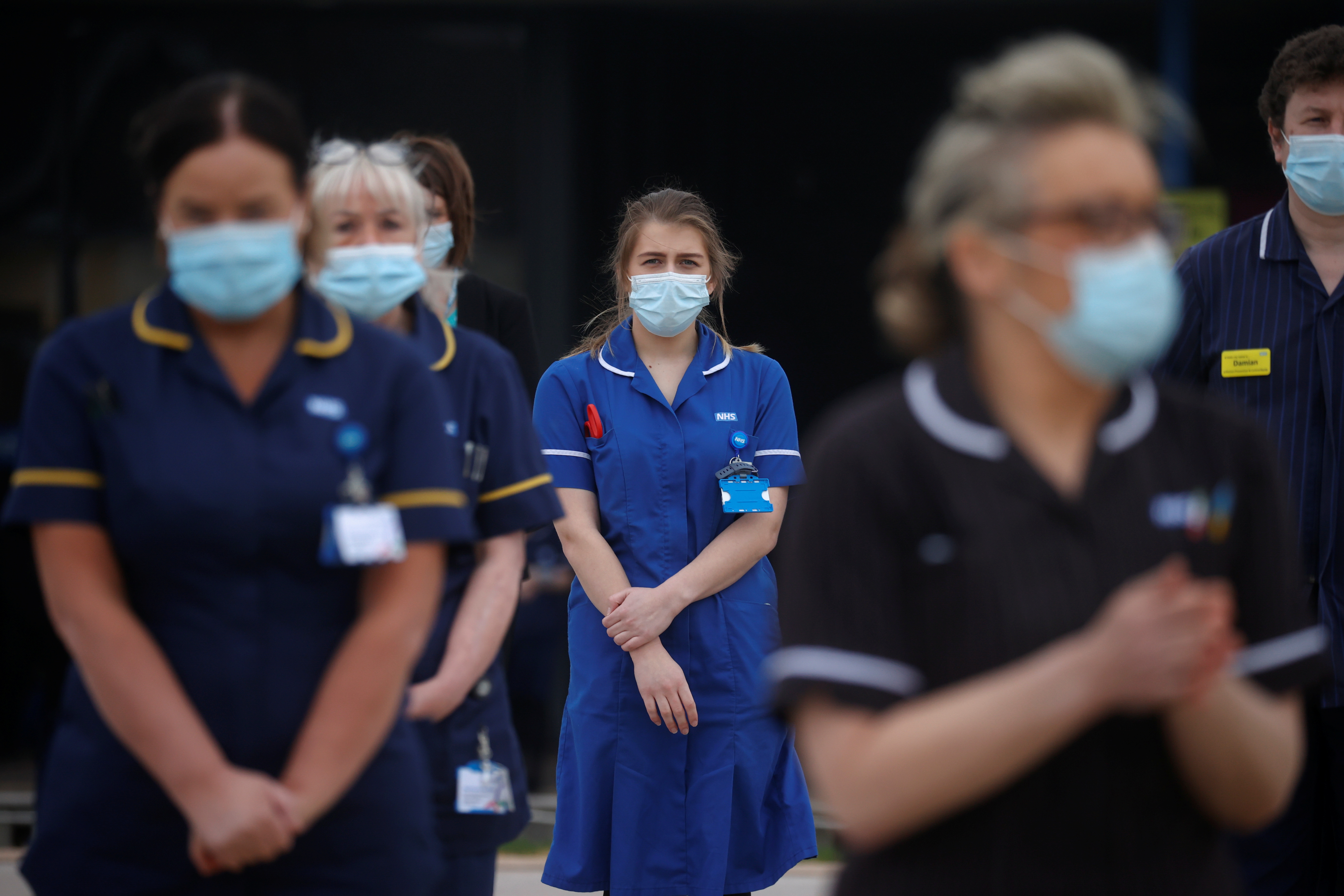 Hospital staff observe a minute's silence as part of a day of reflection to mark the anniversary of Britain's first coronavirus disease (COVID-19) lockdown, outside the Aintree University Hospital in Liverpool, Britain March 23, 2021. REUTERS/Phil Noble