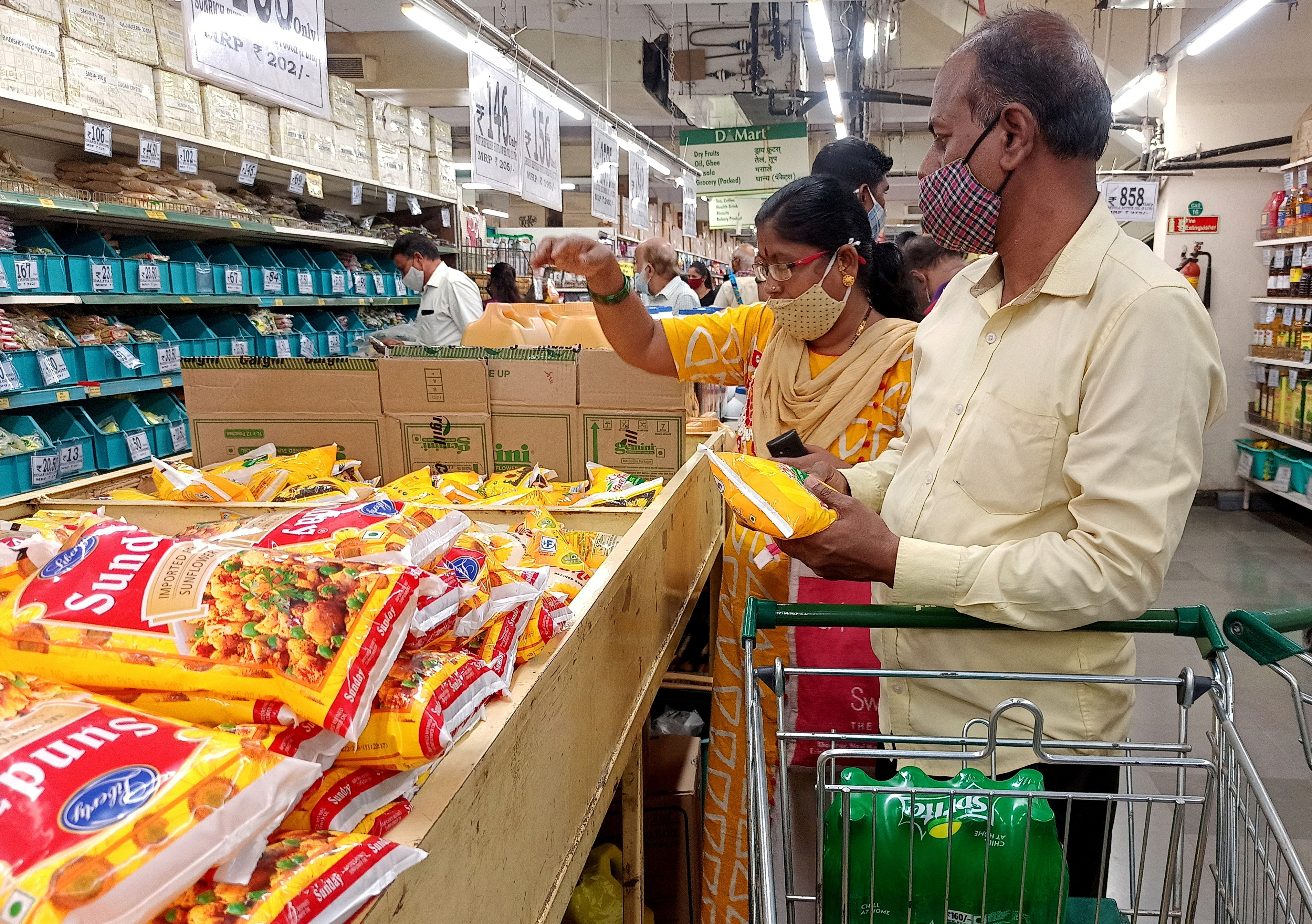 Shoppers purchase packets of vegetable oil at a supermarket in Mumbai