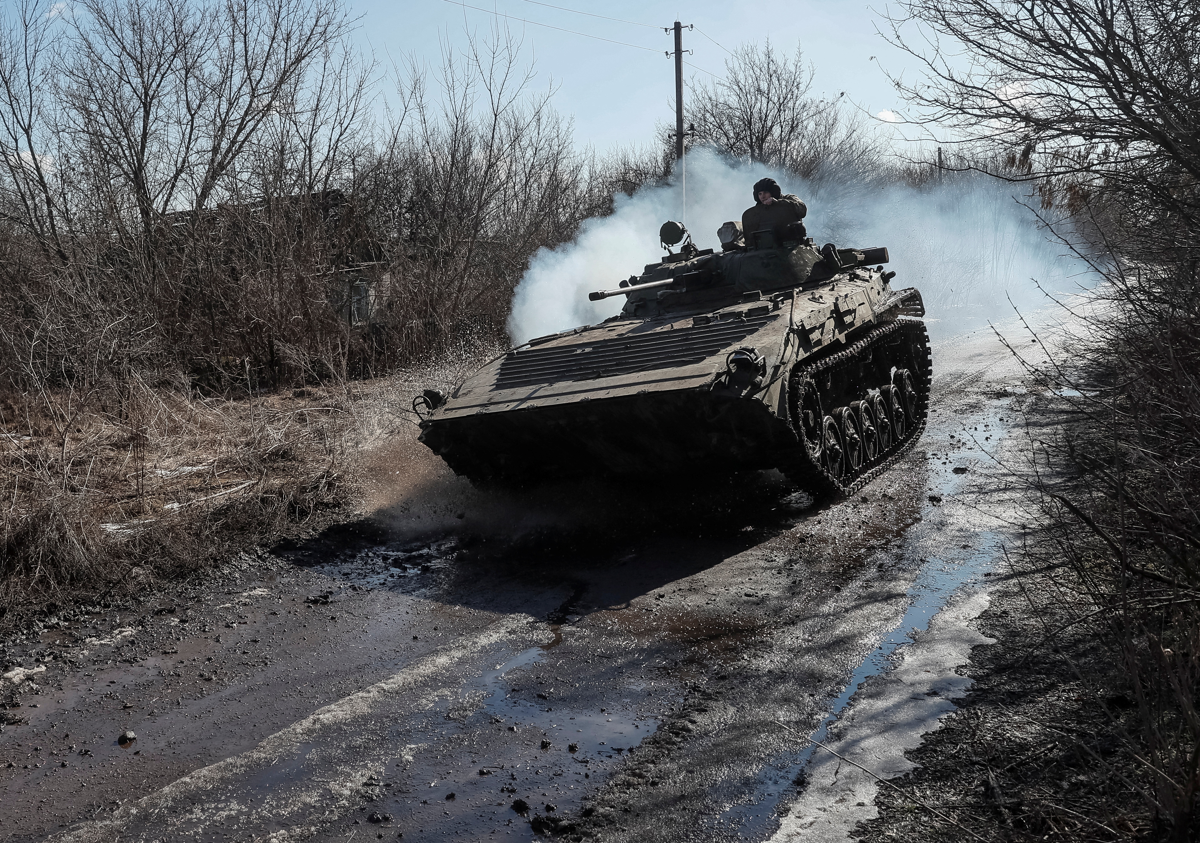 Ukrainian service members ride at a infantry fighting vehicle on the front line near the village of Zaitseve in the Donetsk region