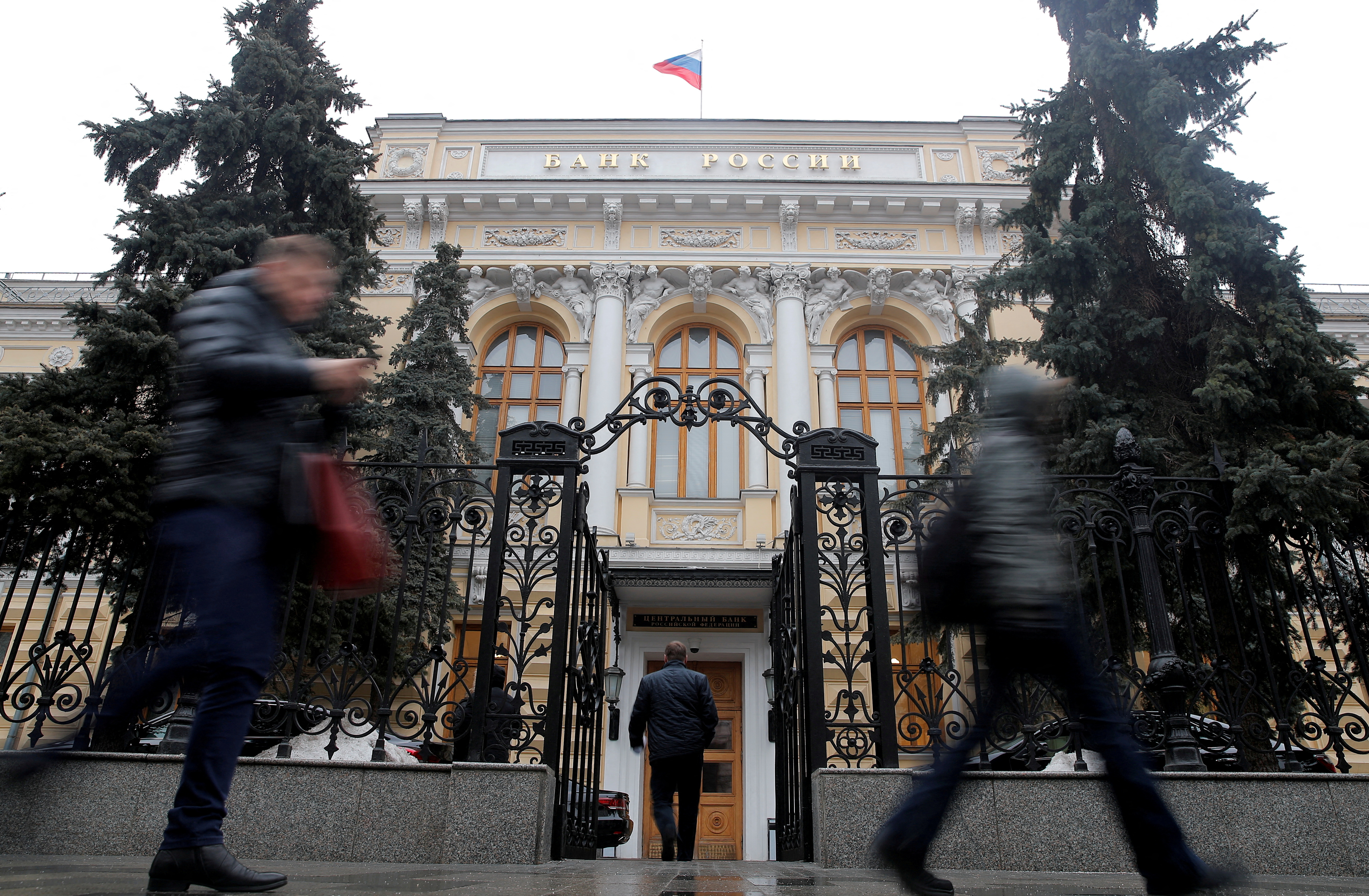 People walk past the headquarters of Russia's Central Bank in Moscow