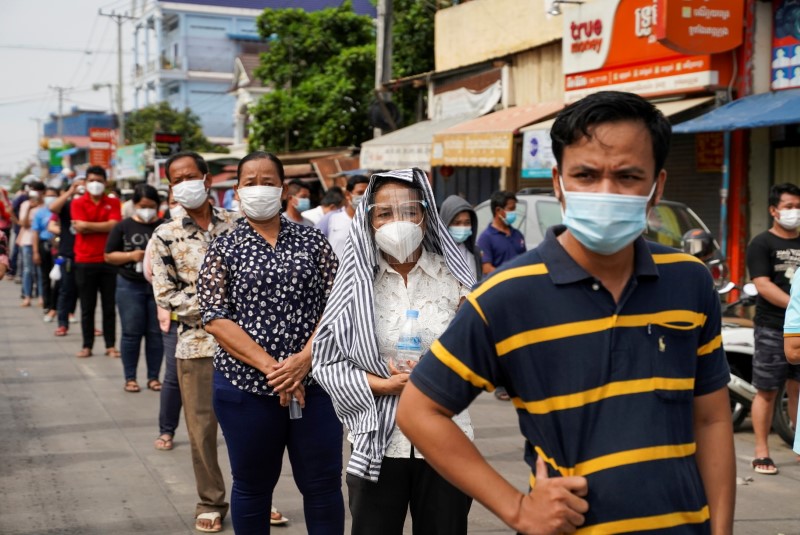 People wait in line before being vaccinated against coronavirus disease in Phnom Penh, Cambodia