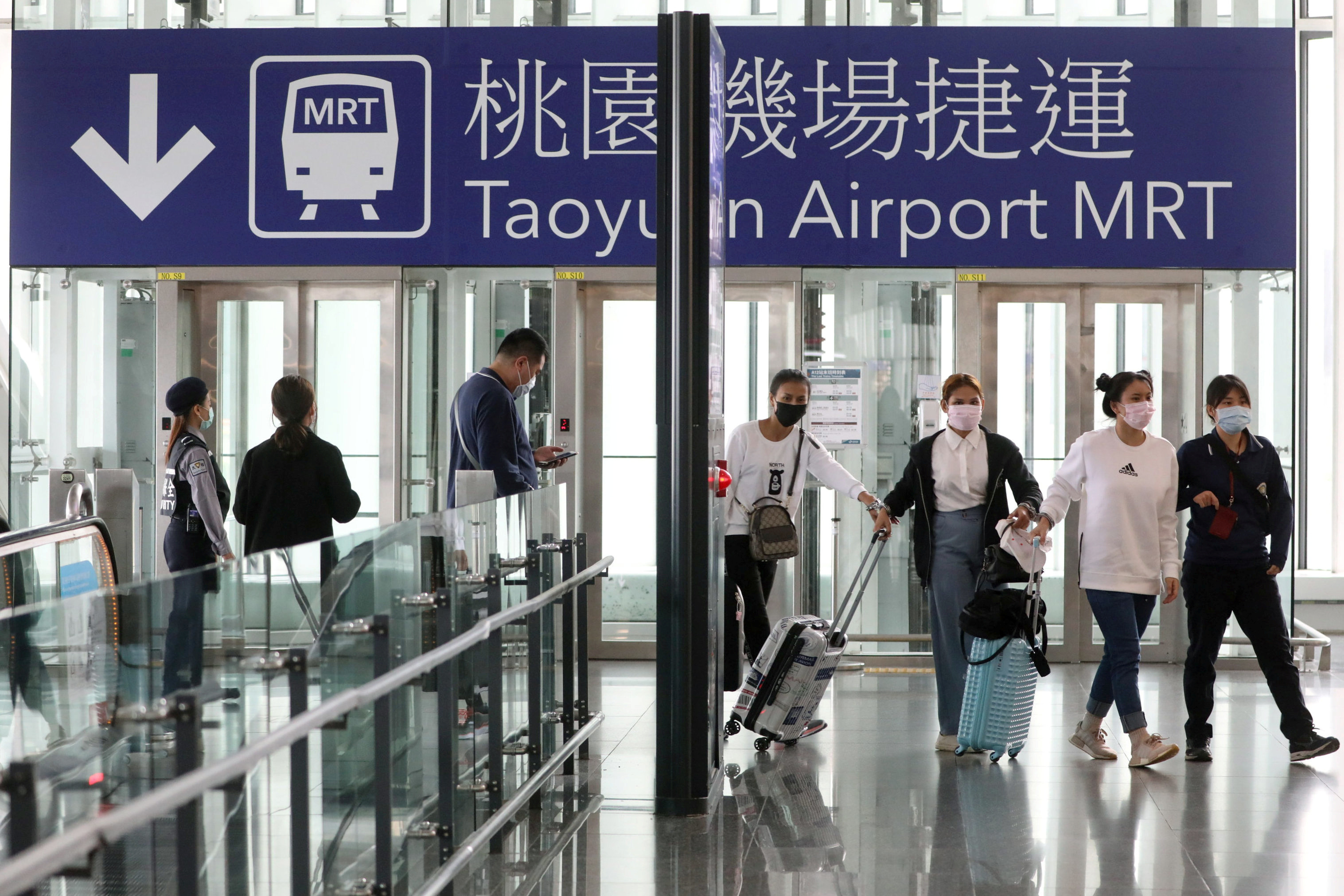 Travelers arrive at the airport as the Taiwanese government announced a ban for most foreigners entering the island at Taoyuan International airport
