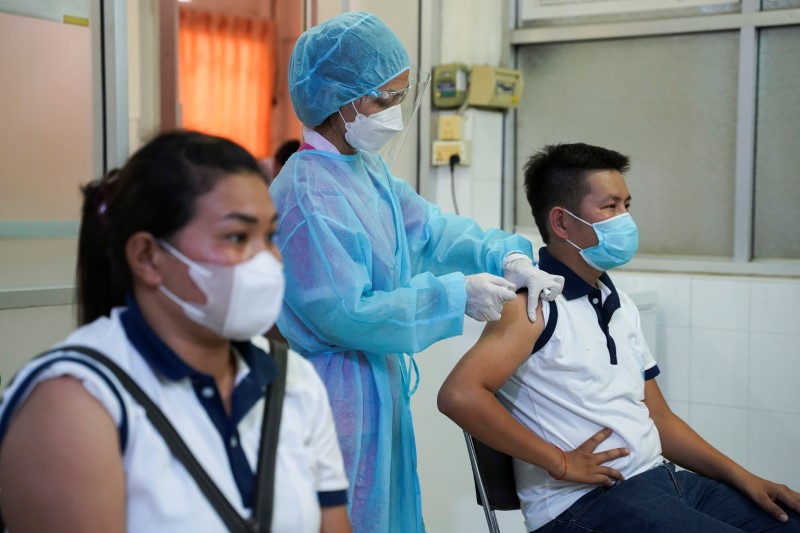 People receive an AstraZeneca coronavirus disease (COVID-19) vaccine as a booster dose in Phnom Penh