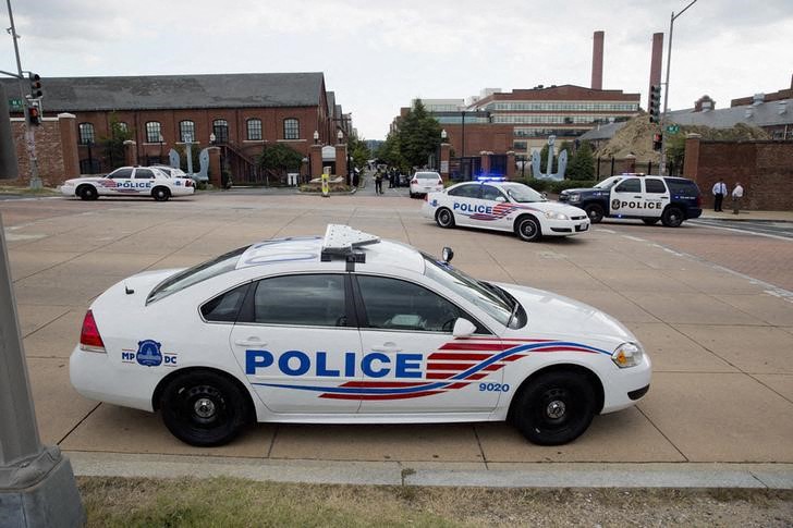 Police cars are parked outside the U.S. Navy Yard after a shooting in Washington