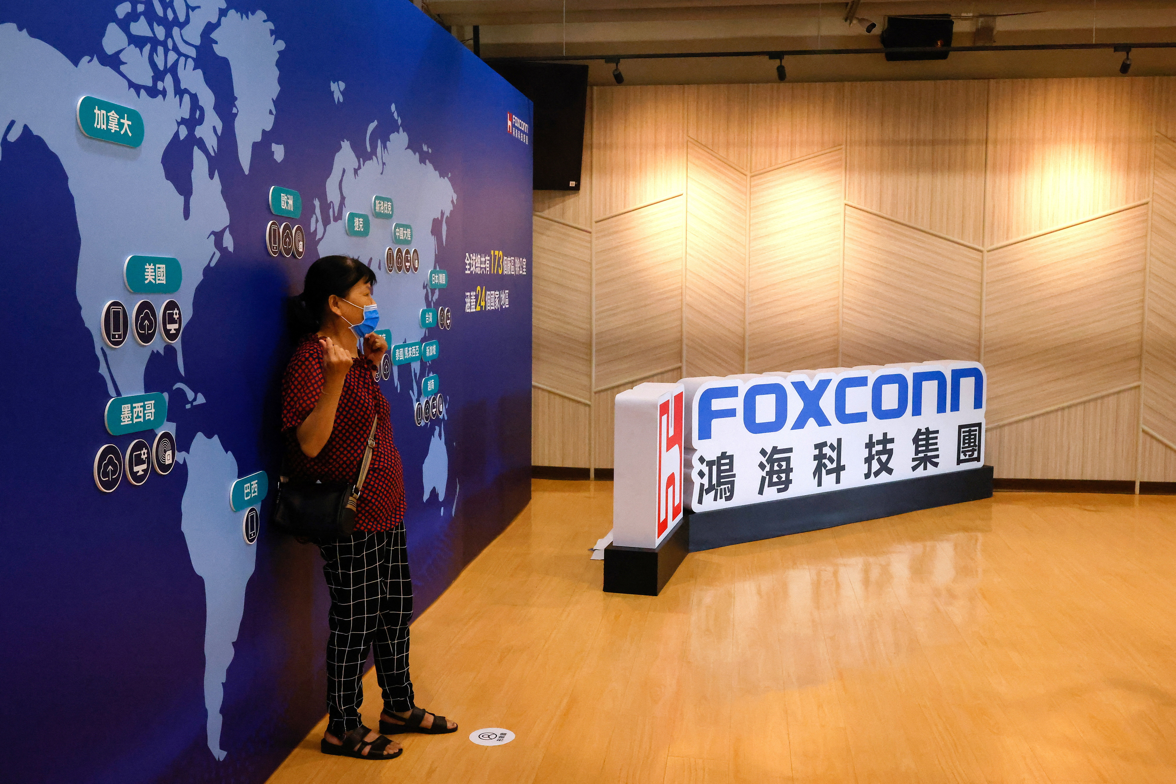 A Foxconn shareholder poses for photos after the annual shareholder meeting in New Taipei City