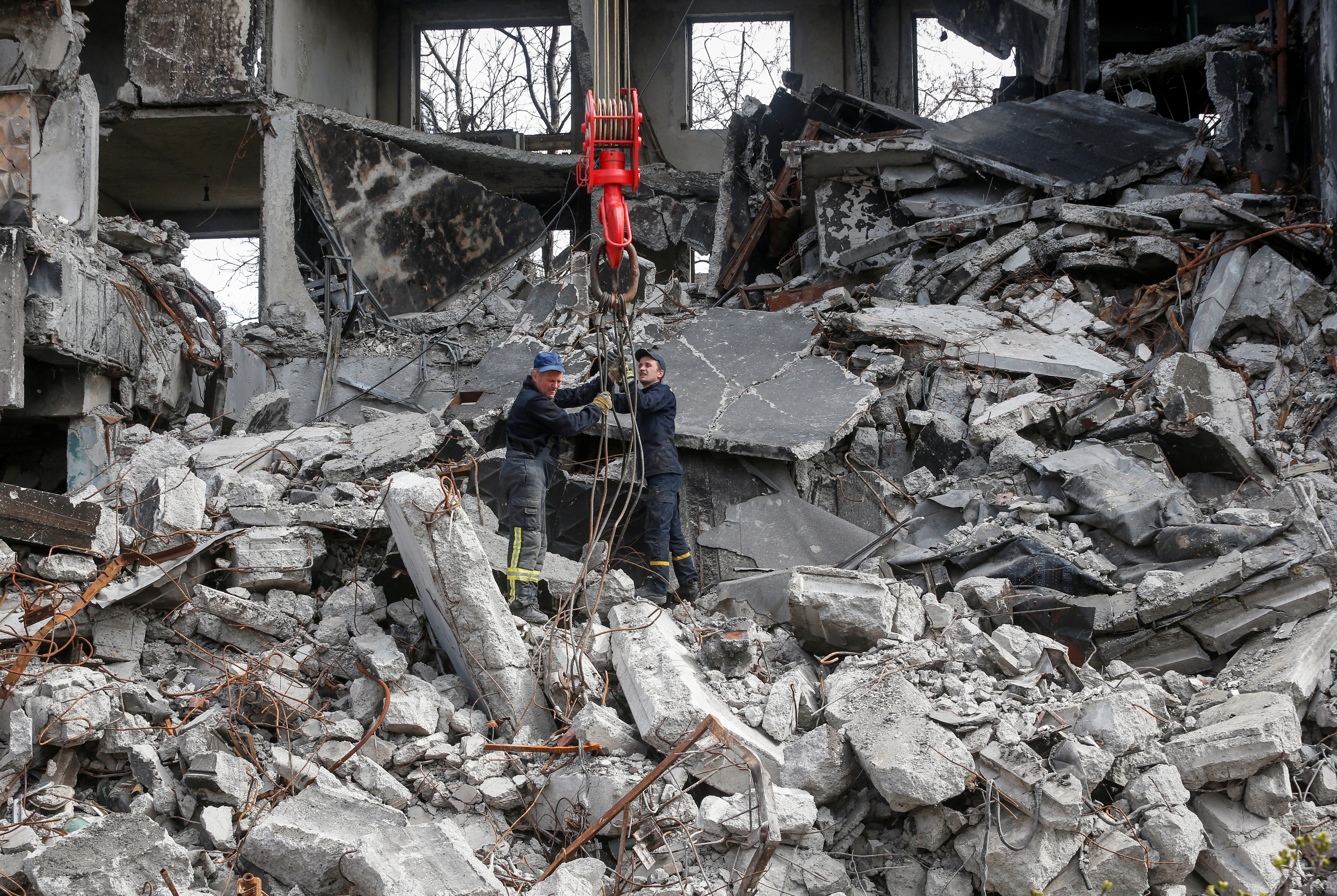 Emergency workers remove debris of a building destroyed in the course of the Ukraine-Russia conflict, in Mariupol