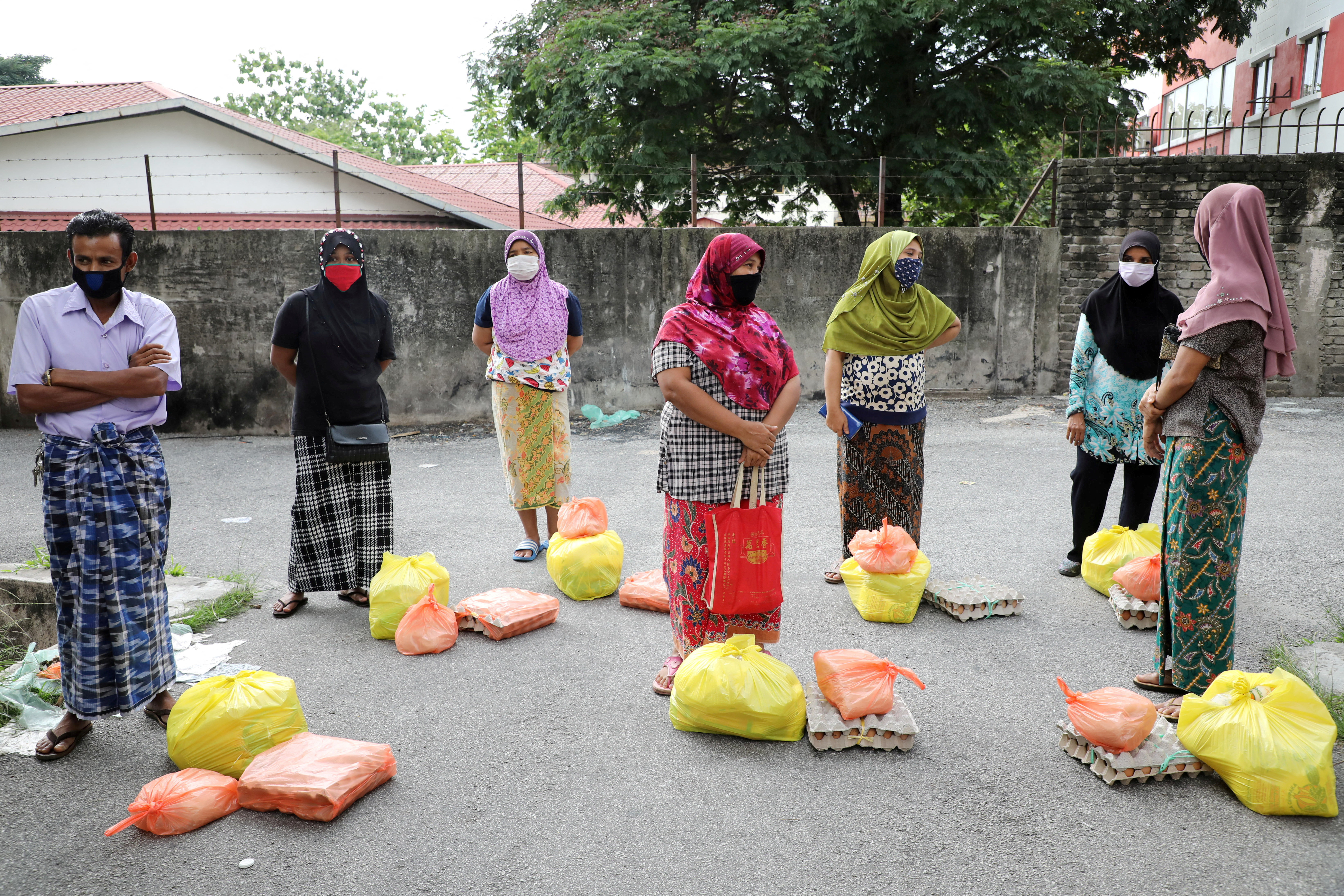 Rohingya refugees wearing protective masks keep a social distance while waiting to receive goods from volunteers, during the movement control order due to the outbreak of the coronavirus disease (COVID-19), in Kuala Lumpur