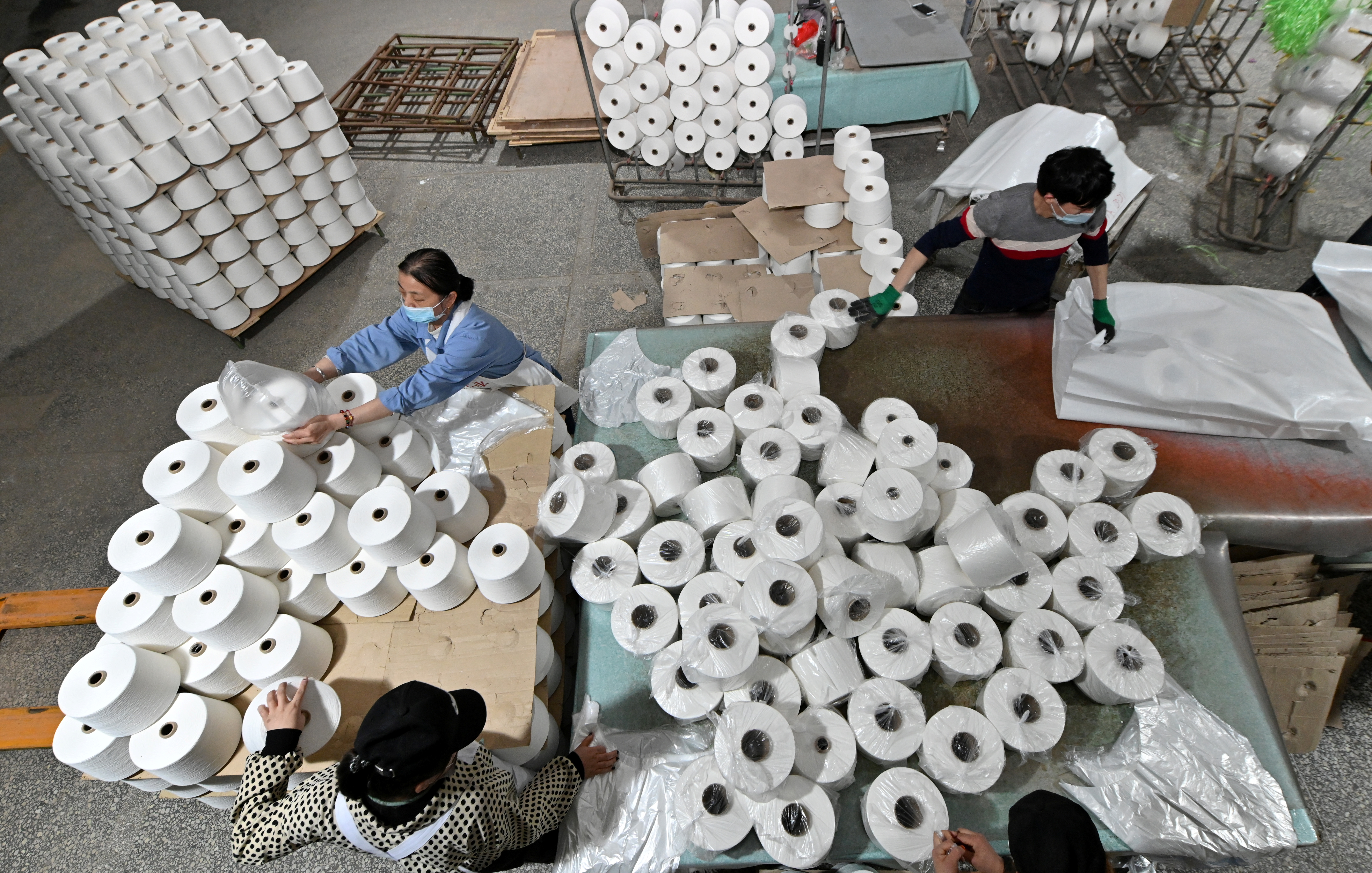 Workers are seen on the production line at a cotton textile factory in Korla