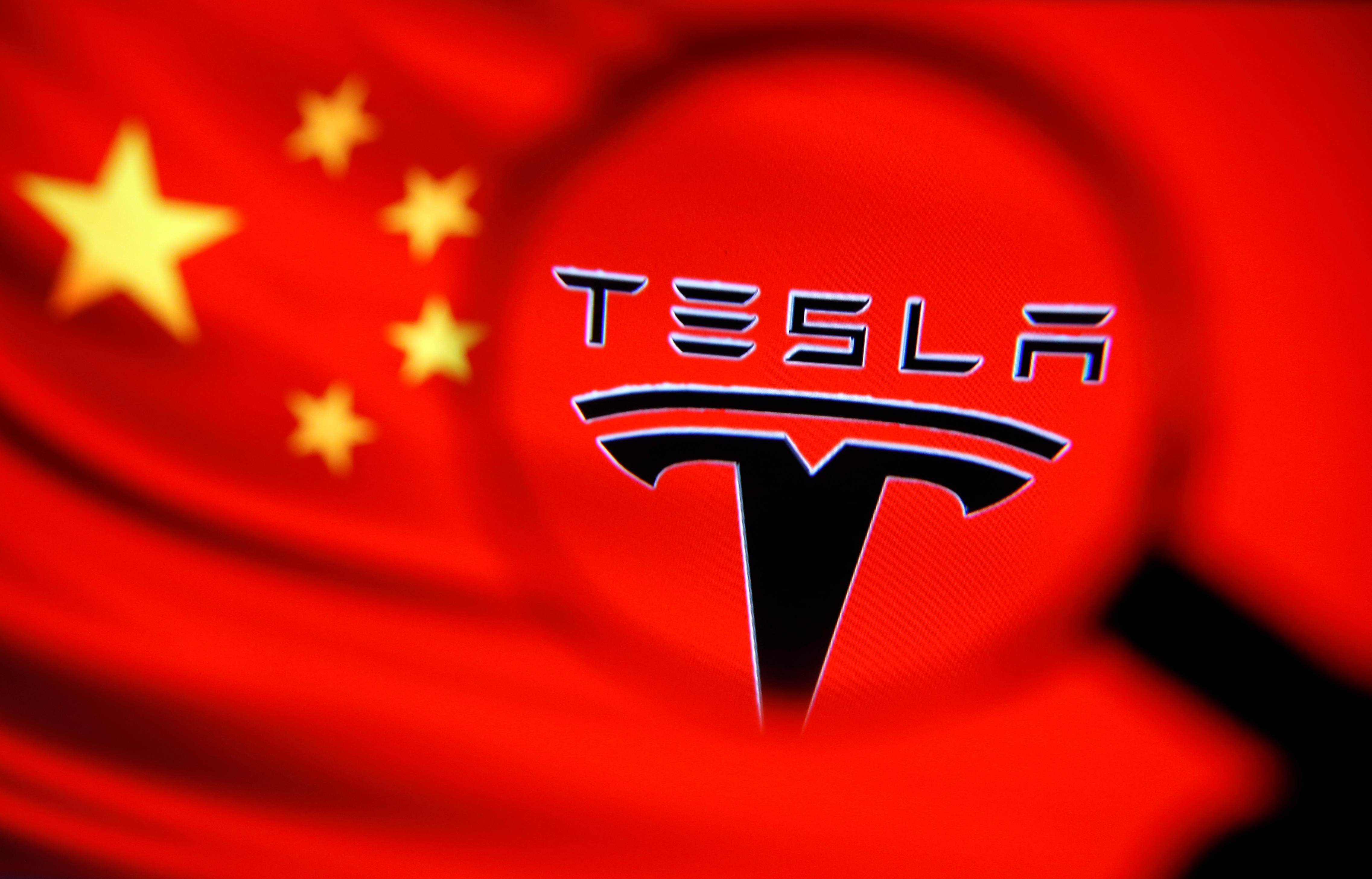 Chinese flag and Tesla logo is seen through a magnifier in this illustration