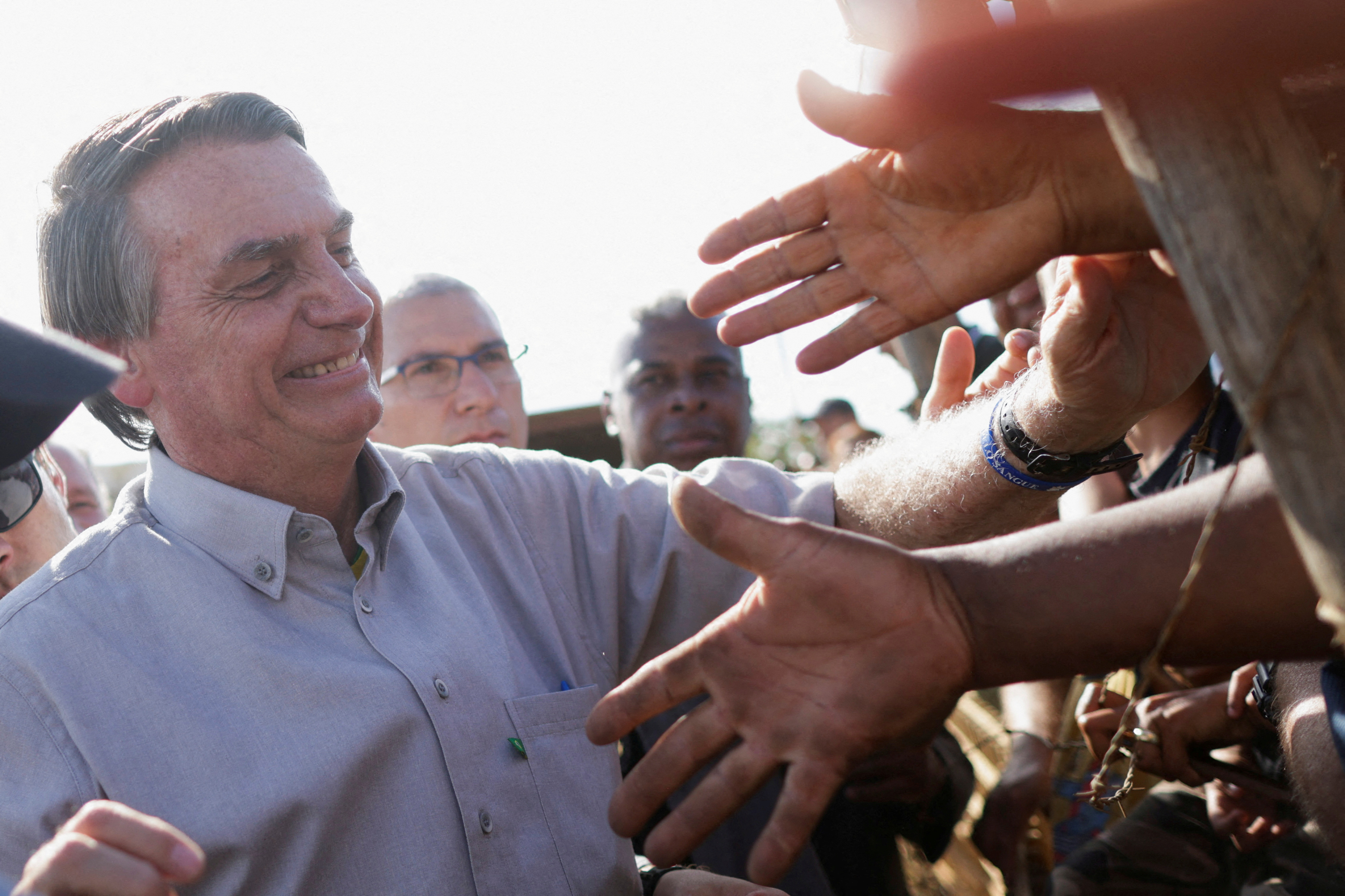 Brazil's President and candidate for re-election Jair Bolsonaro greets supporters during an election campaign at a settlement of rural workers in Brasilia