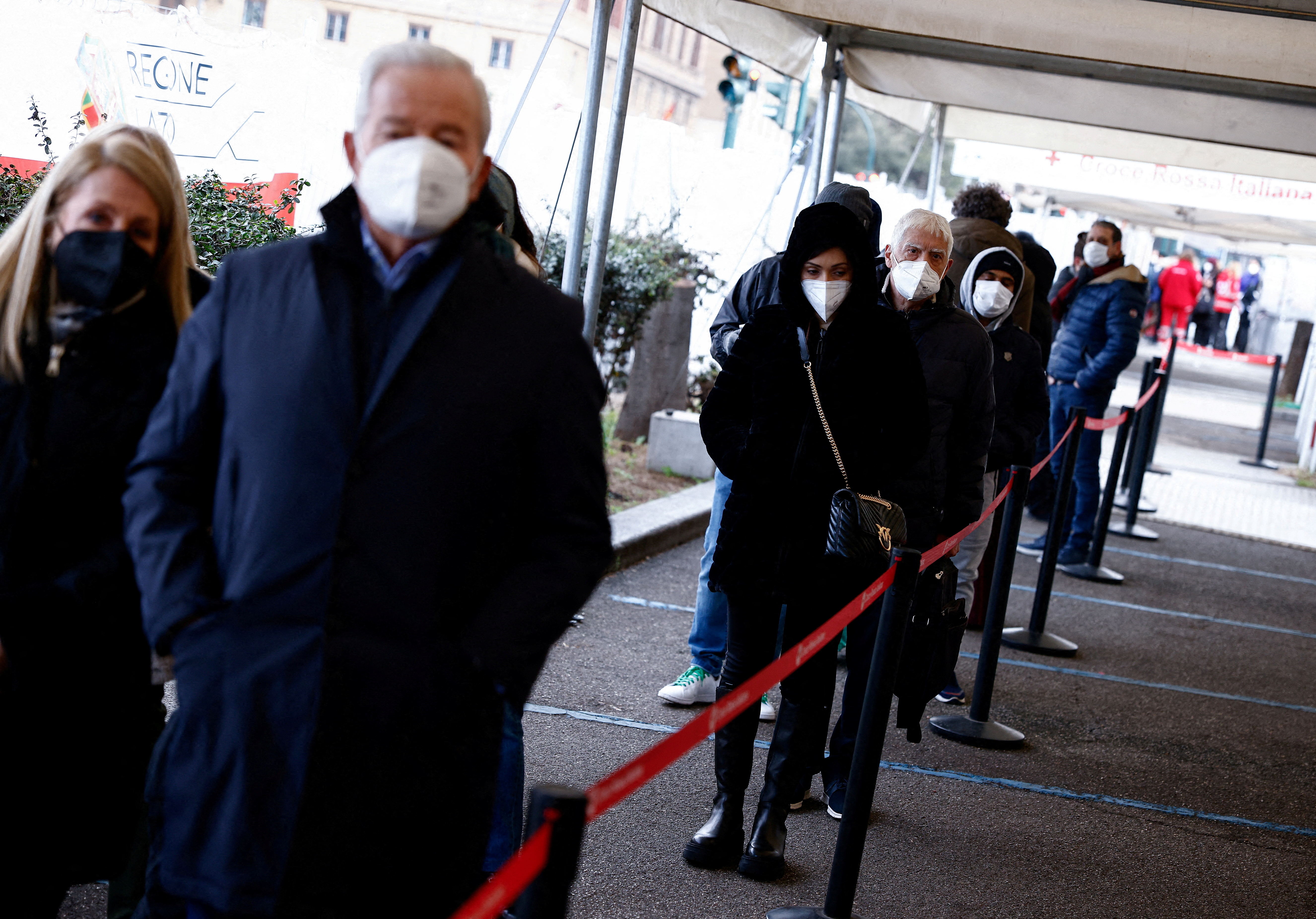 People wait to get a dose of the vaccine against the coronavirus disease (COVID-19), on the day Italy brings in tougher rules for the unvaccinated, at a Red Cross vaccination centre by Termini main train station in Rome, Italy, January 10, 2022. REUTERS/Guglielmo Mangiapane