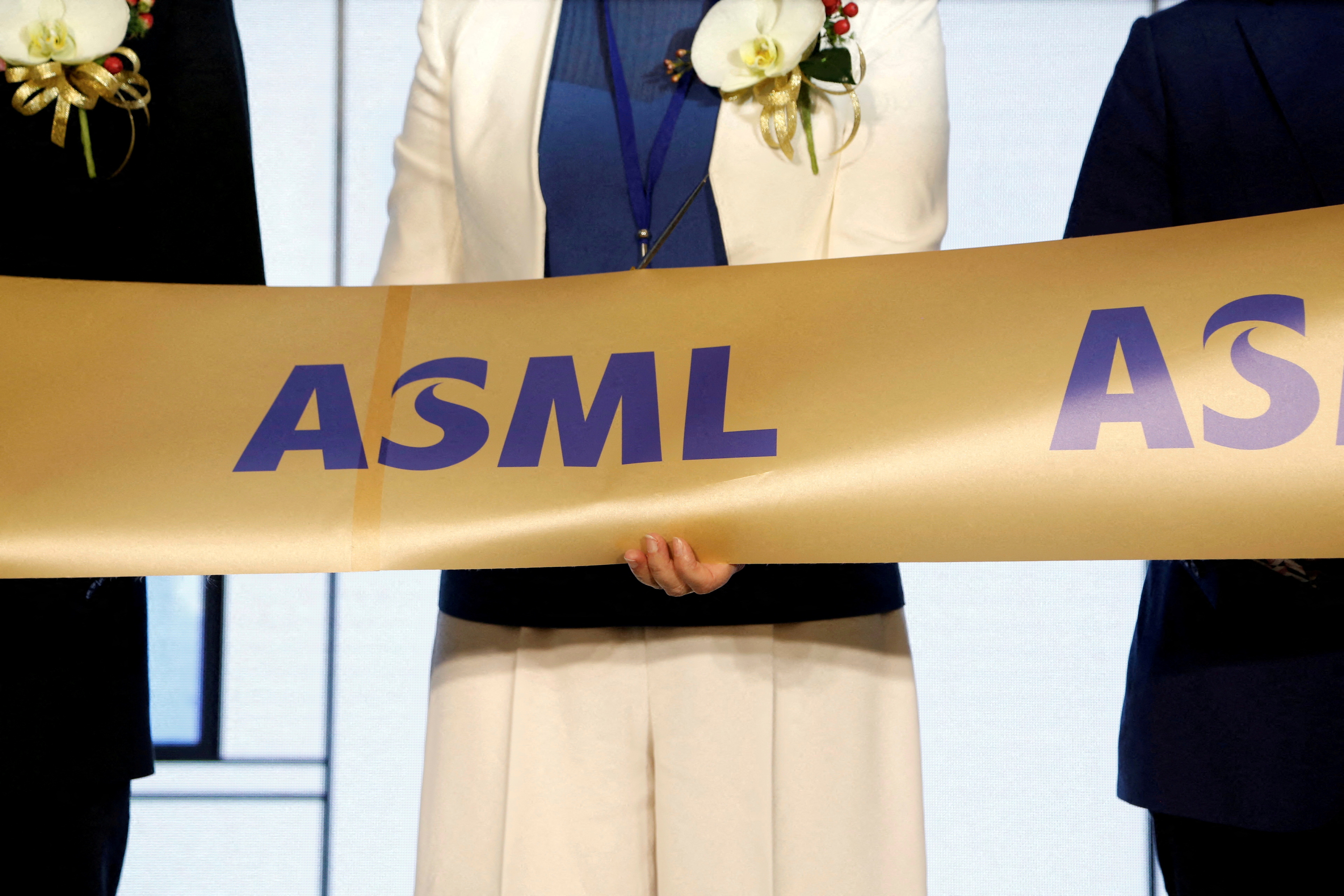 Company representatives and government officials cut a ribbon during the opening ceremony of the EUV training center at ASML Holding in Tainan