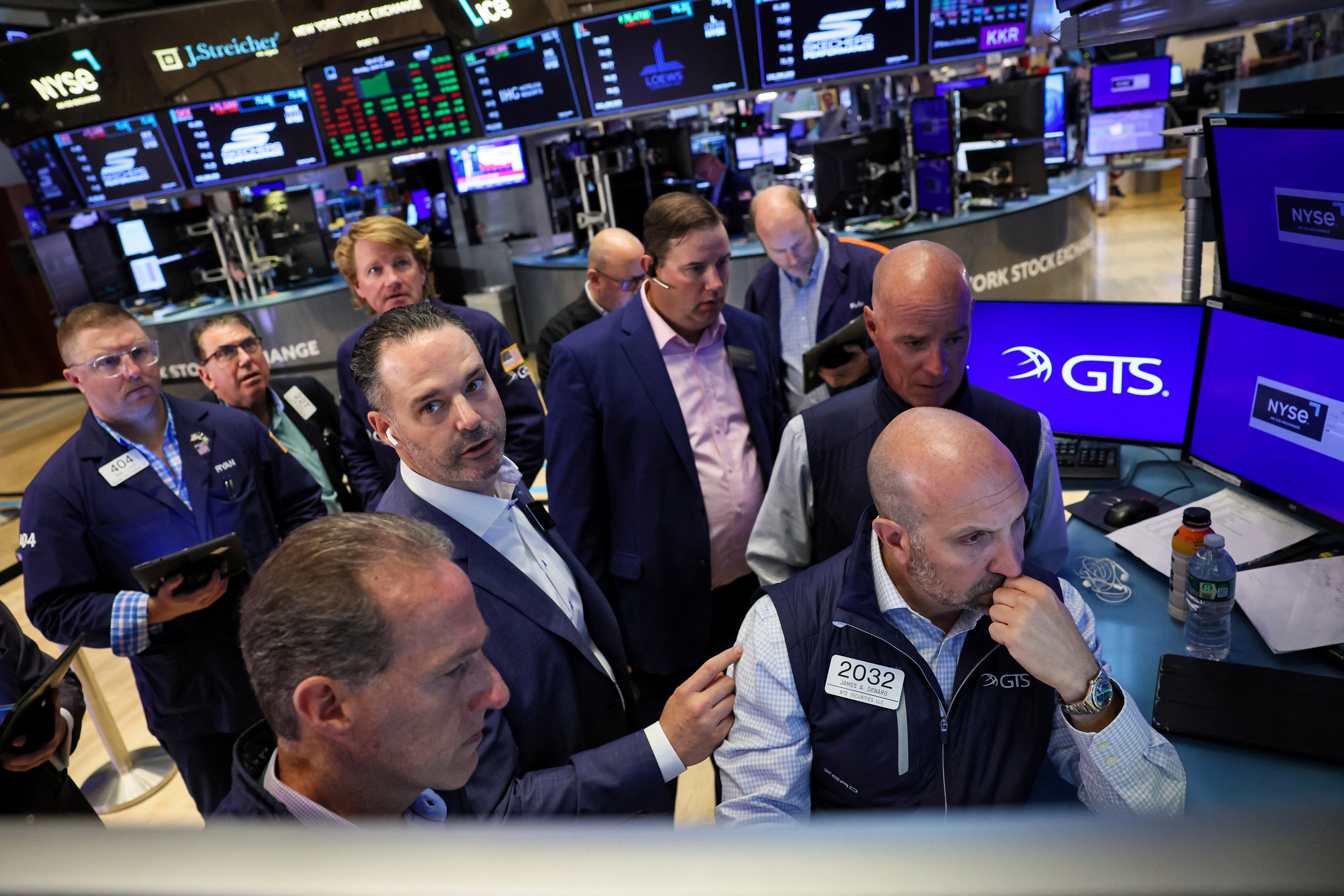 Traders and floor officials react to technical issues on the floor of the NYSE in New York