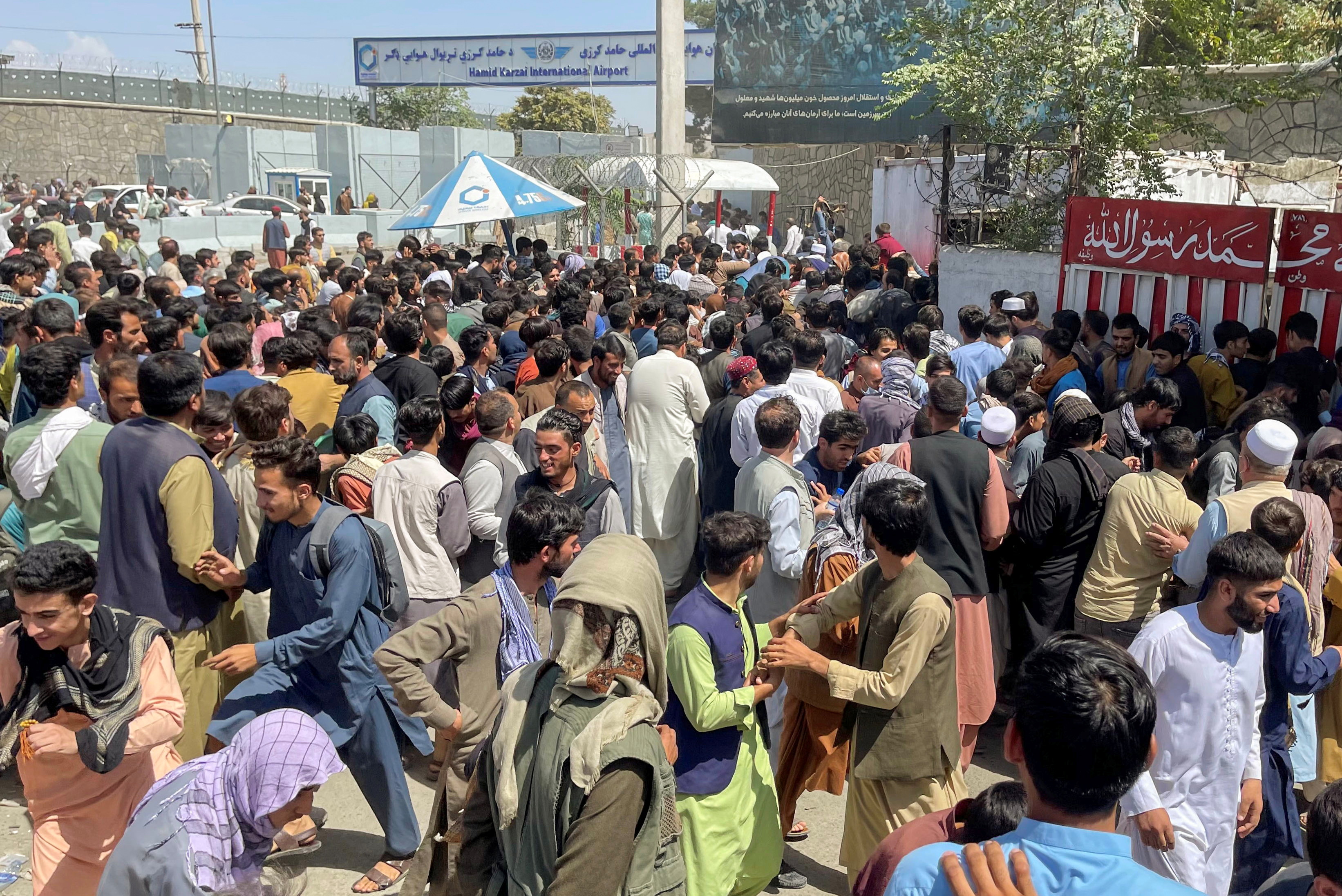 People try to get into Hamid Karzai International Airport in Kabul, Afghanistan August 16, 2021. REUTERS/Stringer 