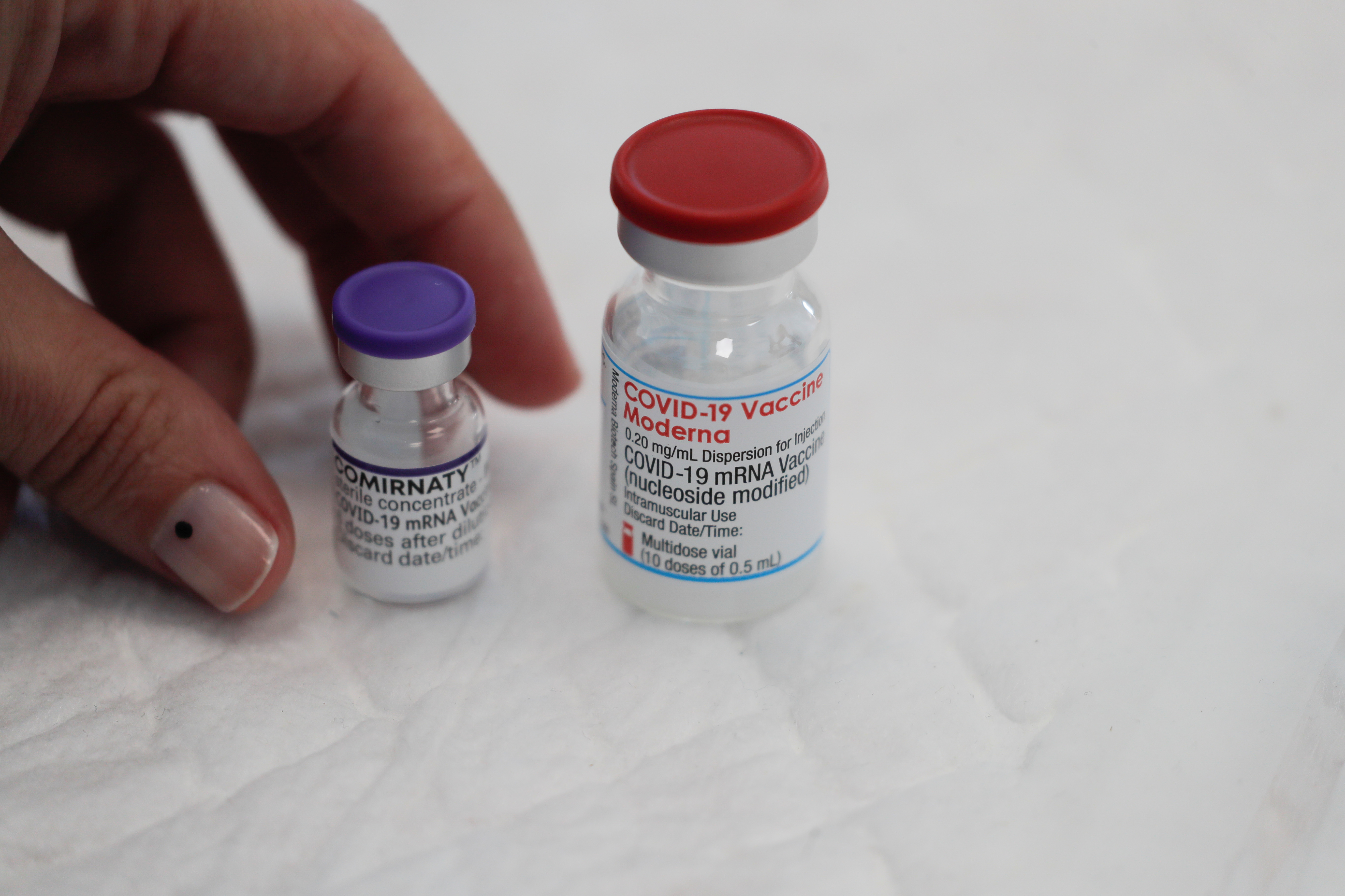 A healthcare worker places vials containing doses of the 