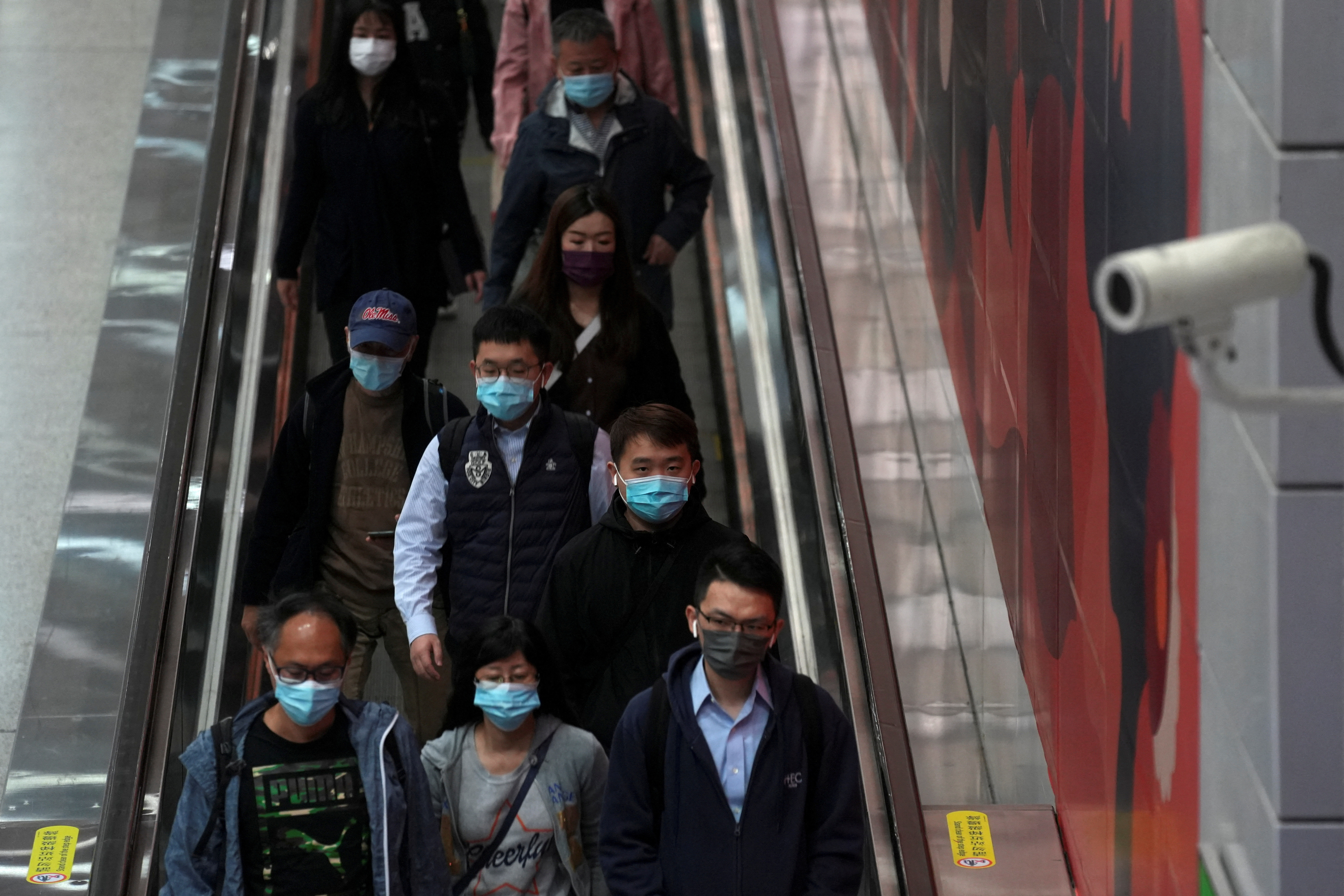 Passengers wearing masks walk at a subway station in Hong Kong