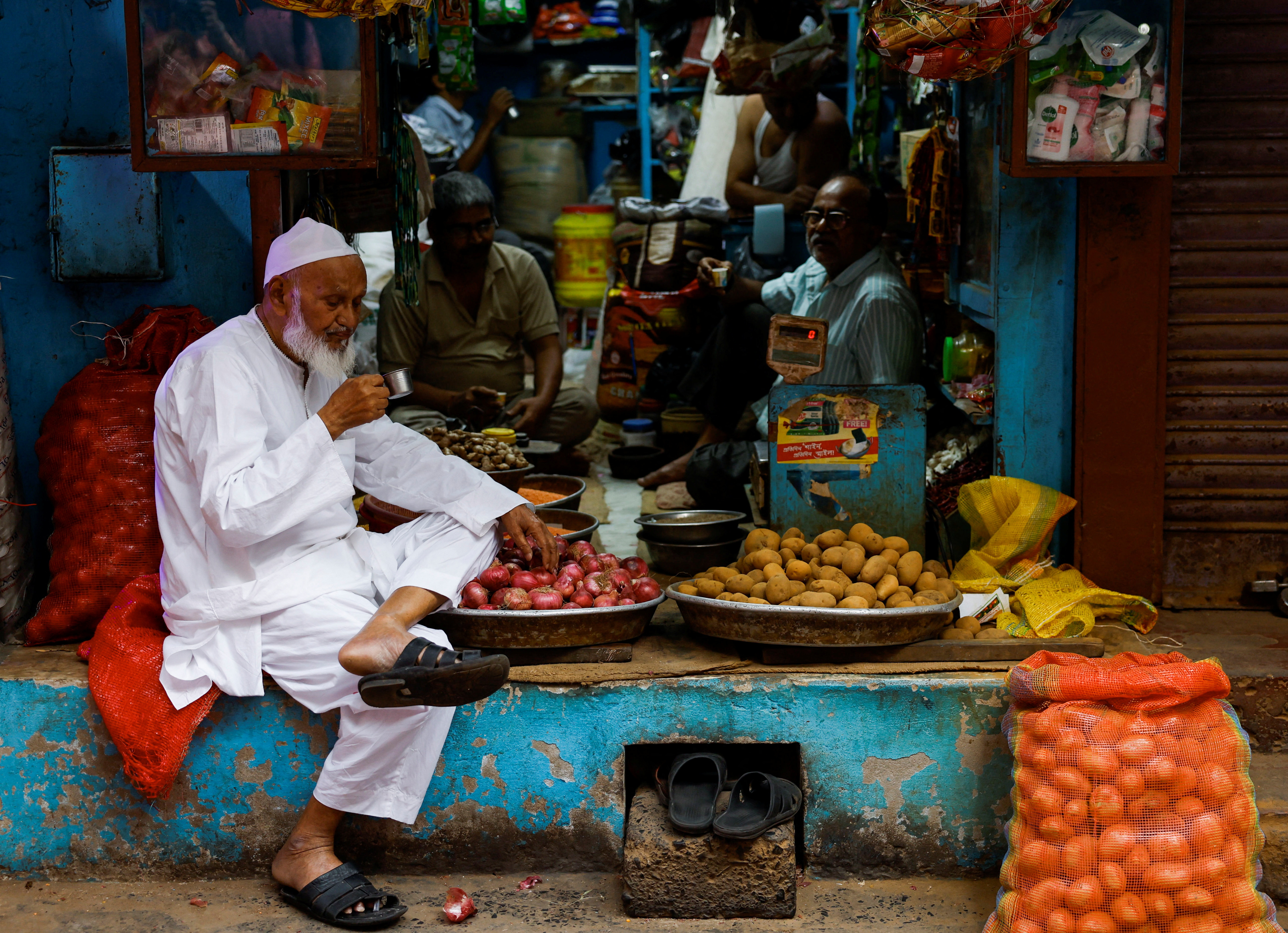 Shopkeepers take a tea break as they wait for customers at a wholesale market in Kolkata
