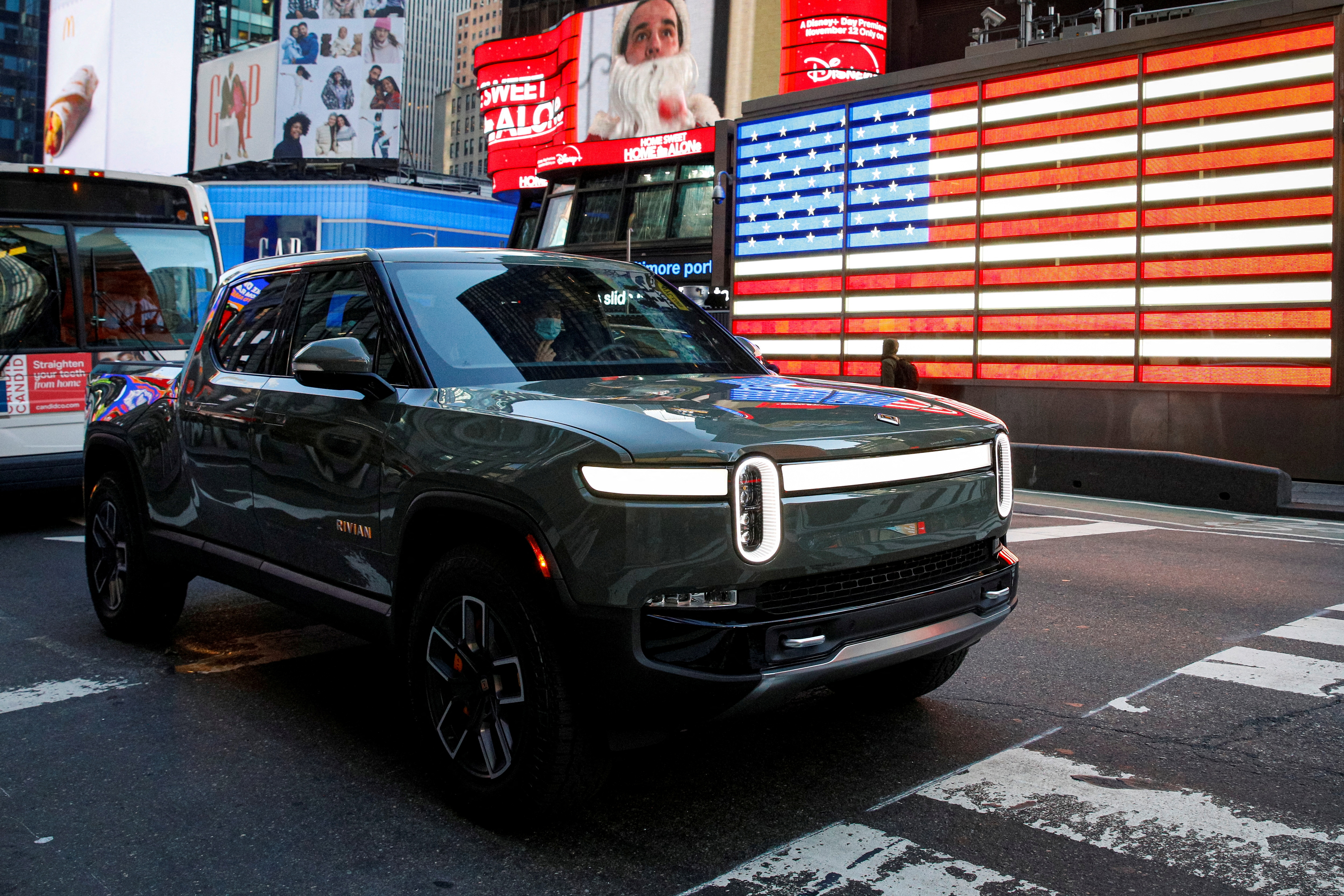 A Rivian R1T pickup is driven through Times Square