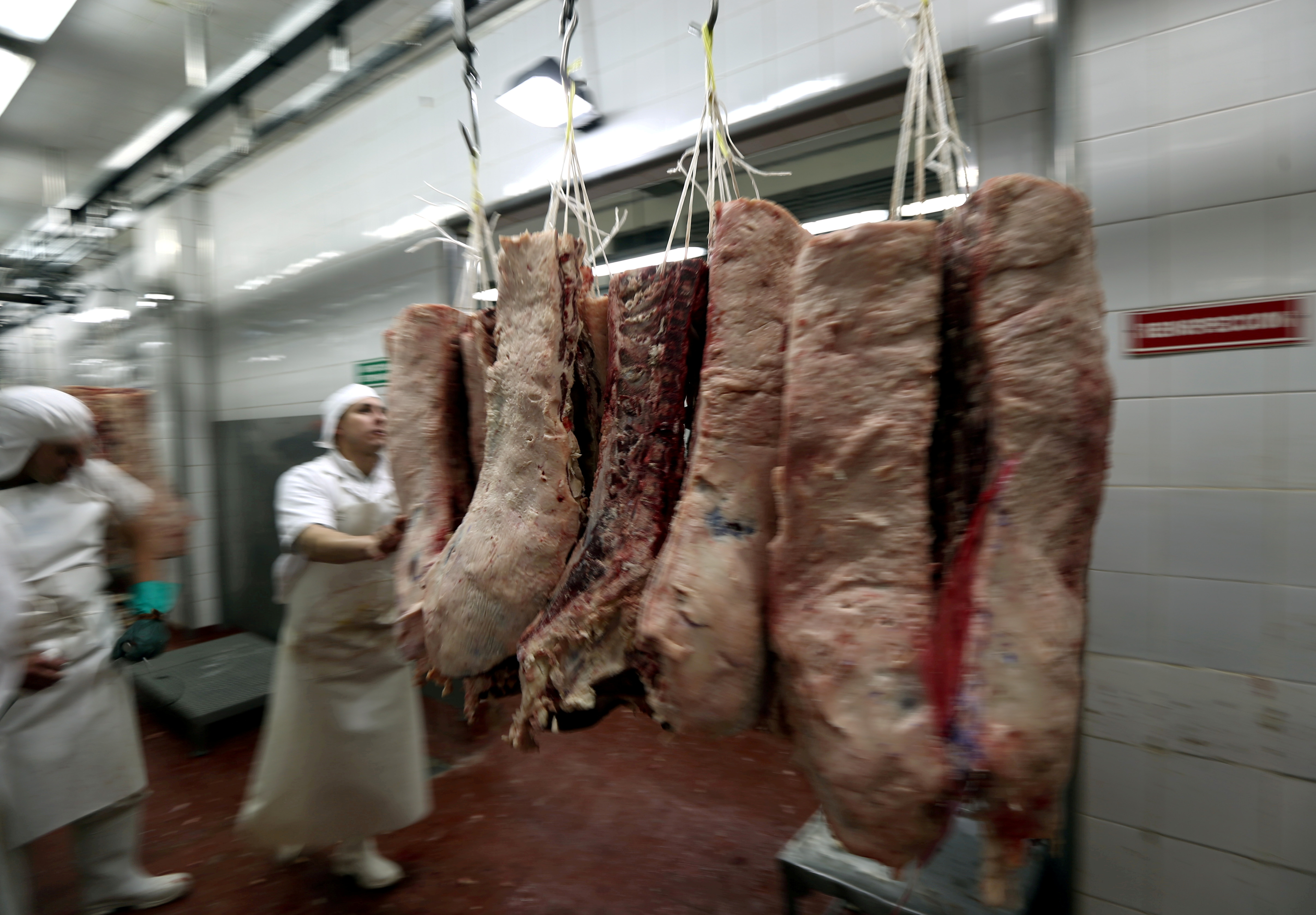 A worker handles beef carcasses at the Ecocarne Meat Plant slaughterhouse in San Fernando