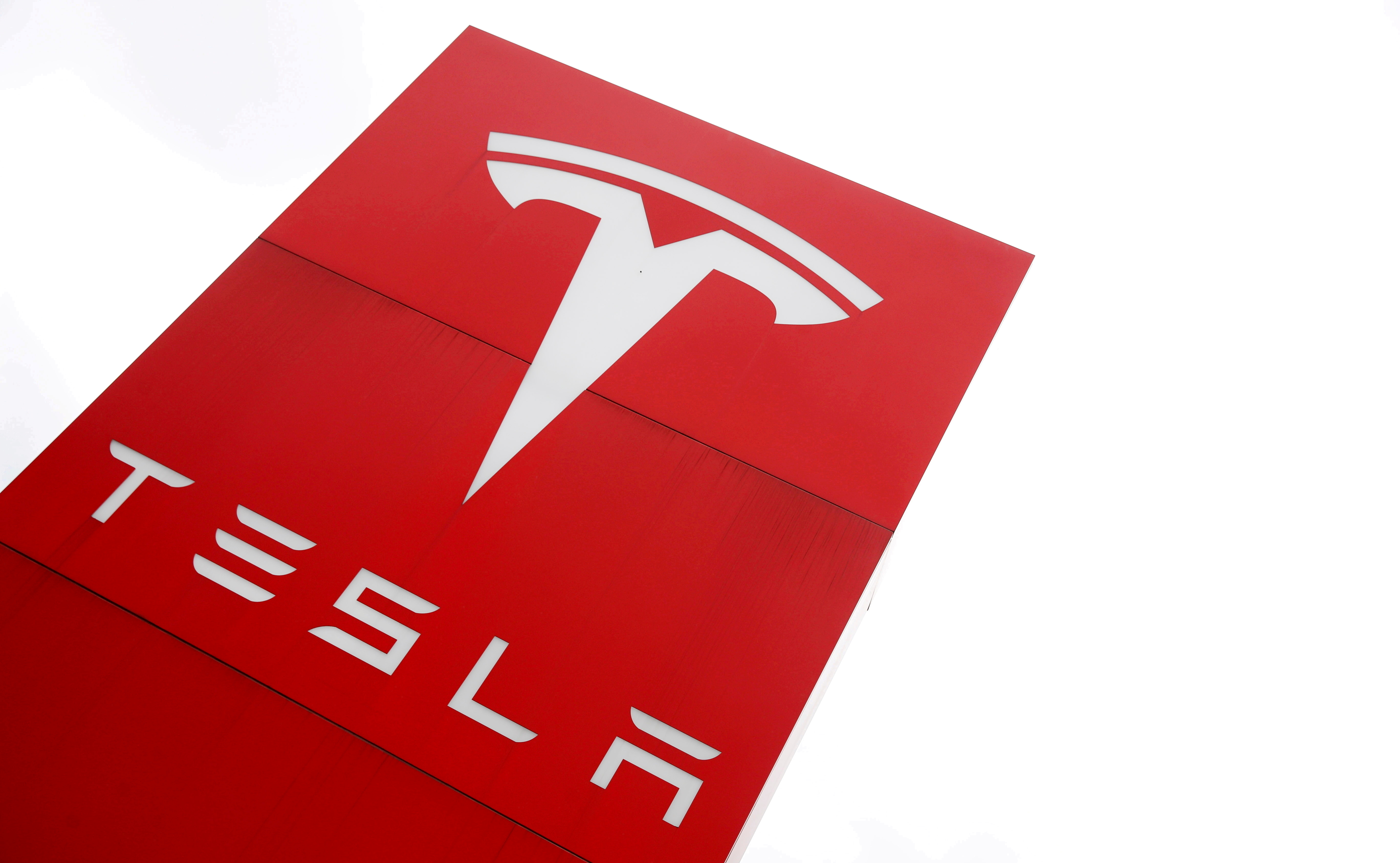The logo of car manufacturer Tesla is seen at a dealership in London, Britain, May 14, 2021. REUTERS/Matthew Childs