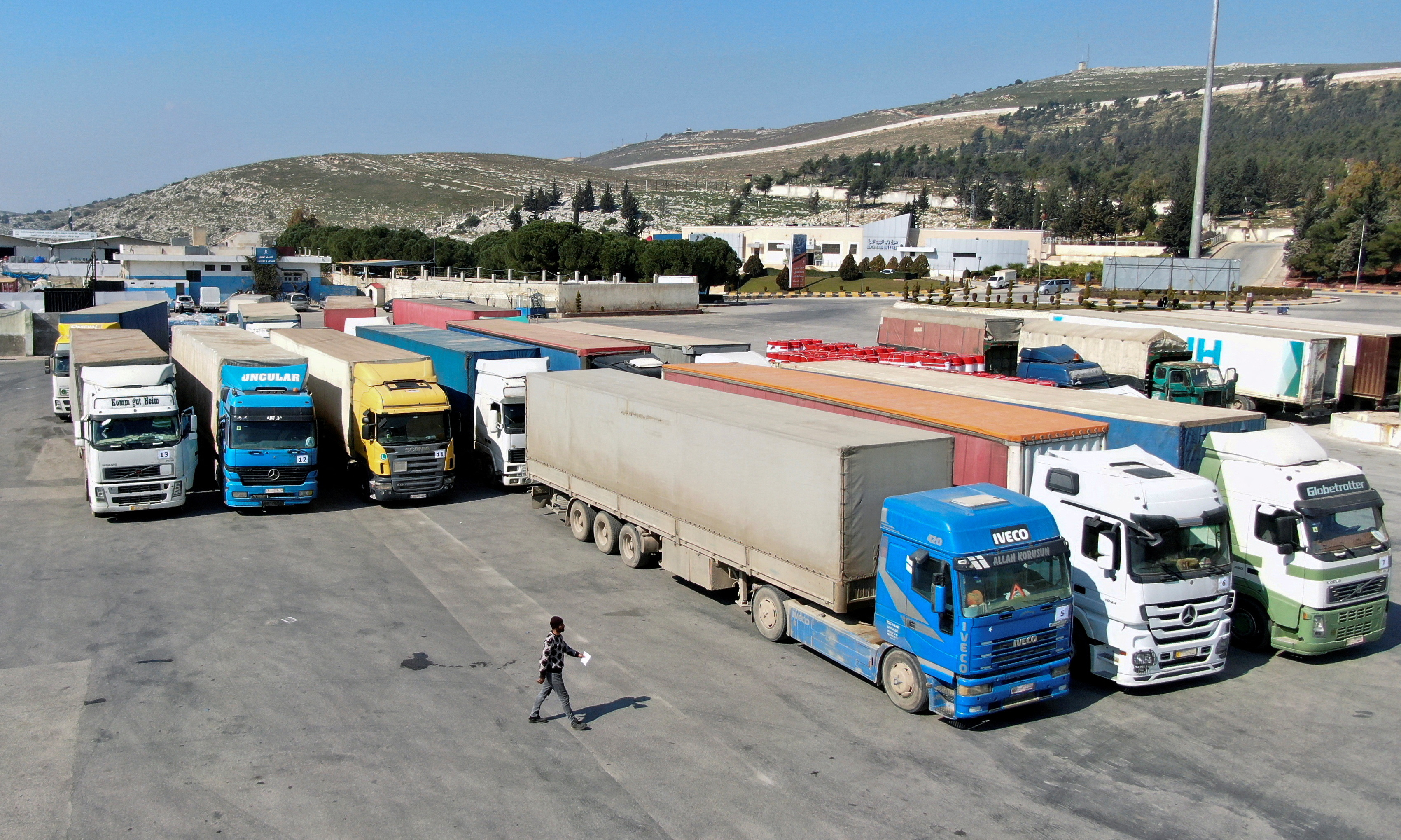 Trucks carrying aid from UN  World Food Programme (WFP) are parked at Bab al-Hawa crossing