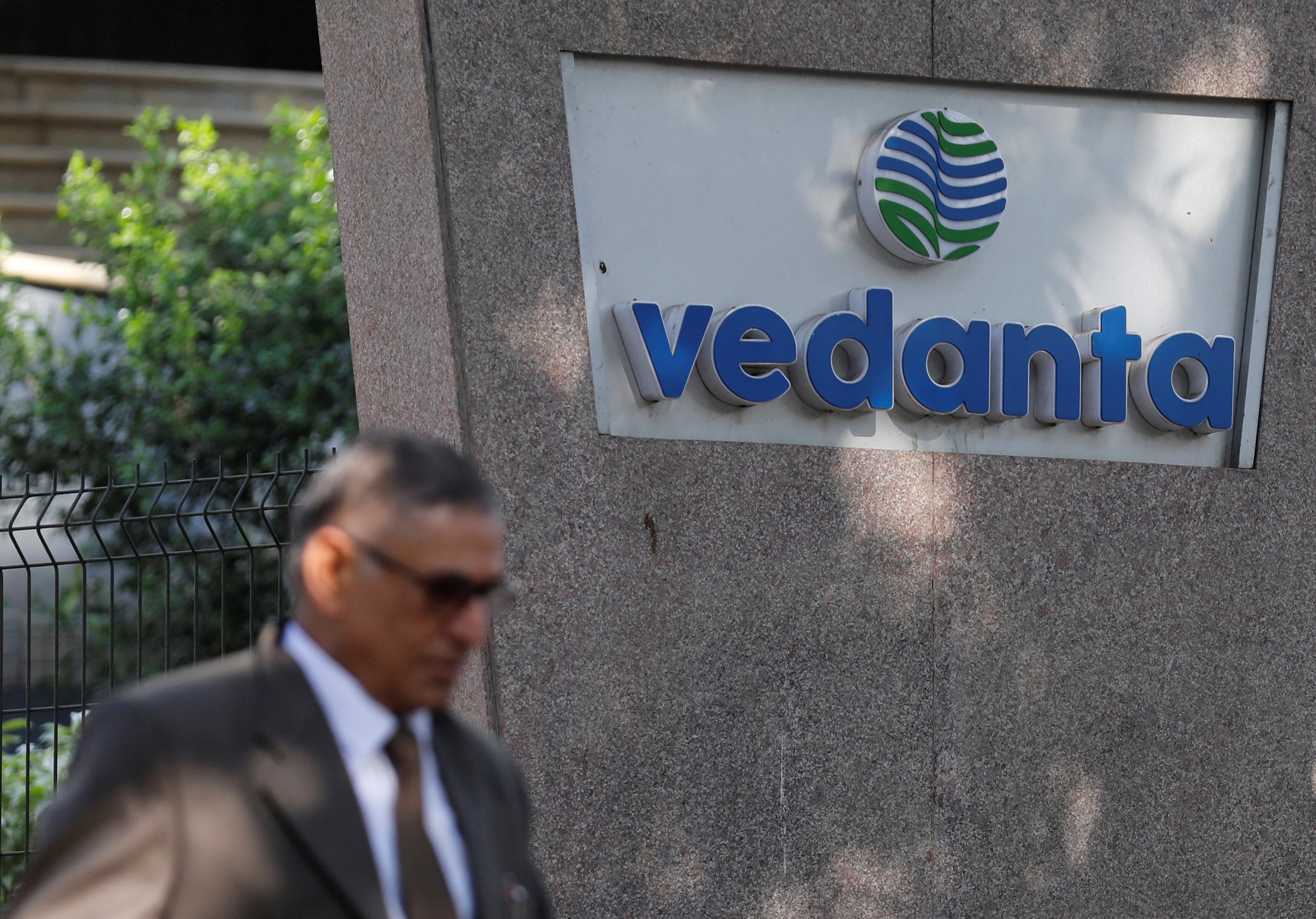 A man walks past the logo of Vedanta outside its headquarters in Mumbai