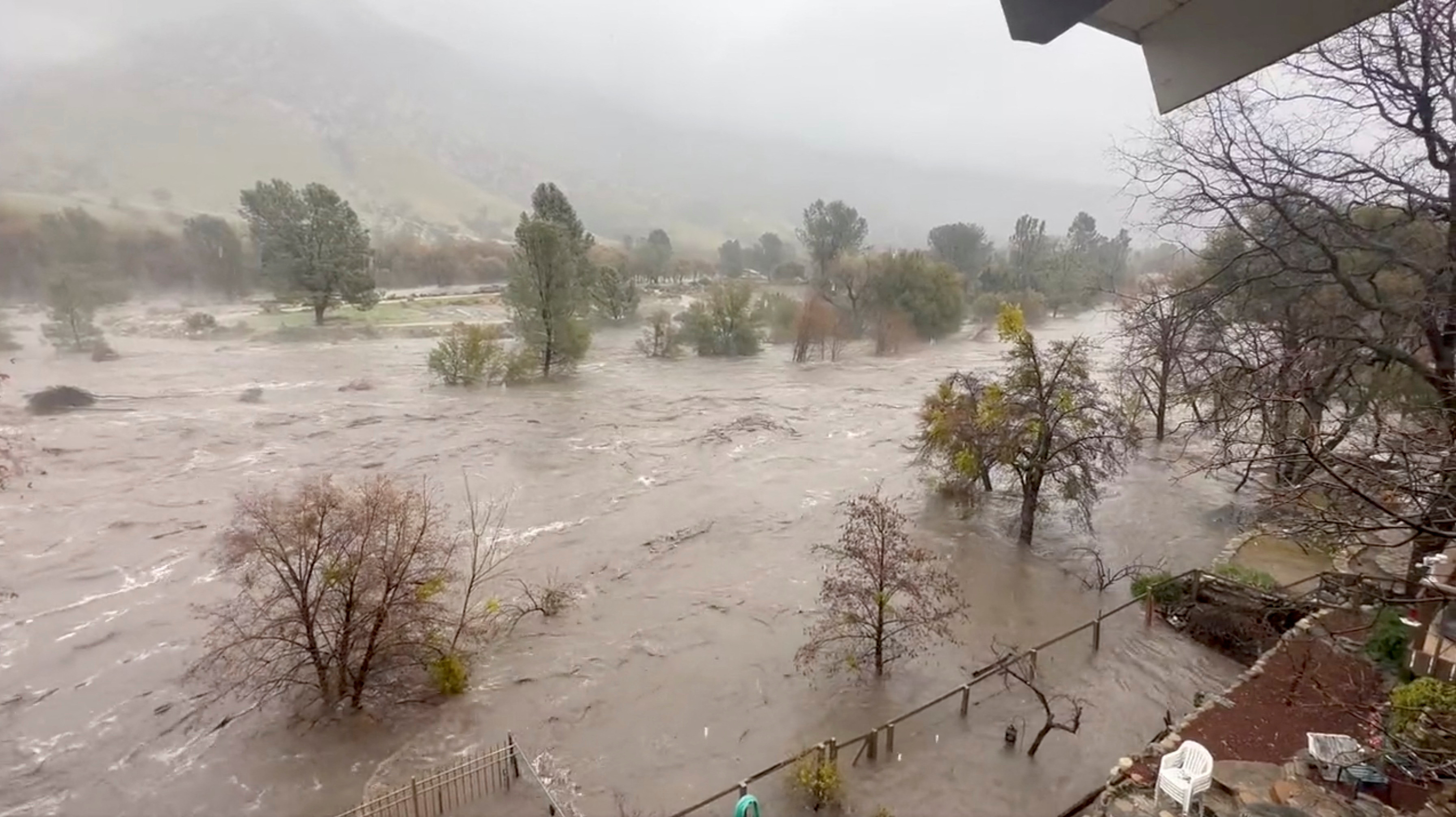 A view shows the overflowing Kern River, as seen from the backyard of a person's house, in Kernville