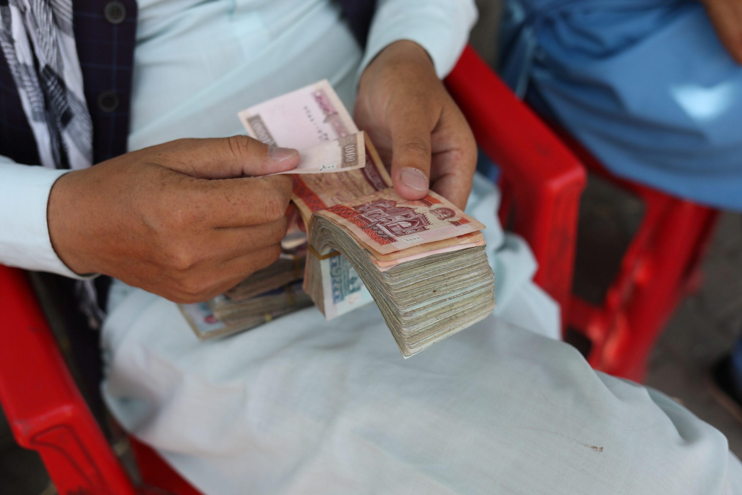 An Afghan man counts his money after the Afghan currency faced devaluation in Kabul, Afghanistan, September 4, 2021. WANA (West Asia News Agency) via REUTERS 