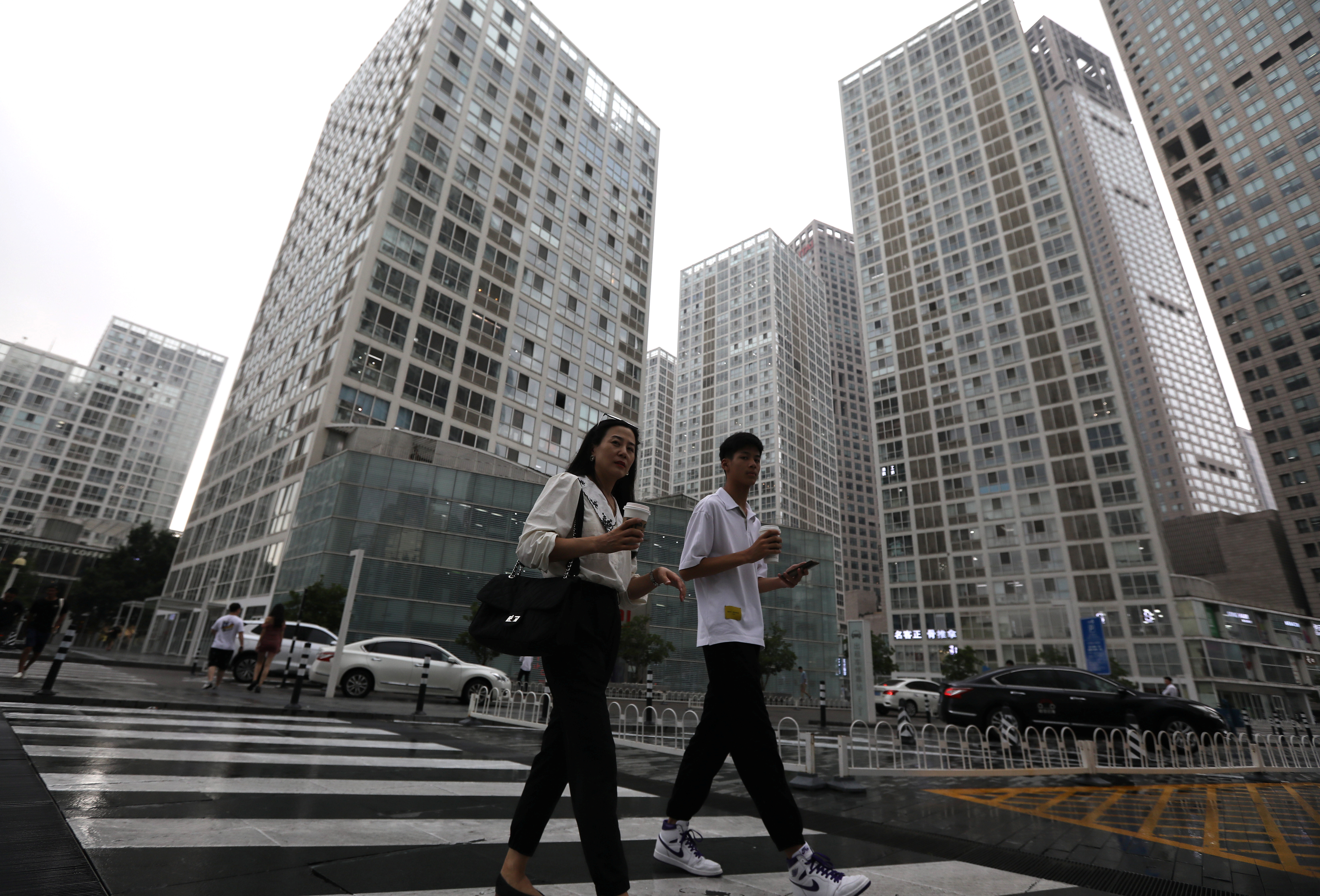 People walk past an office compound in Beijing's Central Business District (CBD),