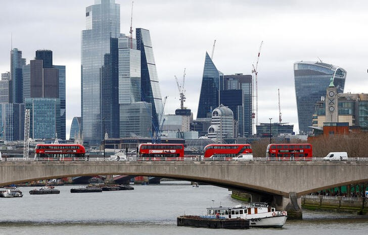 The City of London is seen as buses cross Waterloo Bridge in London