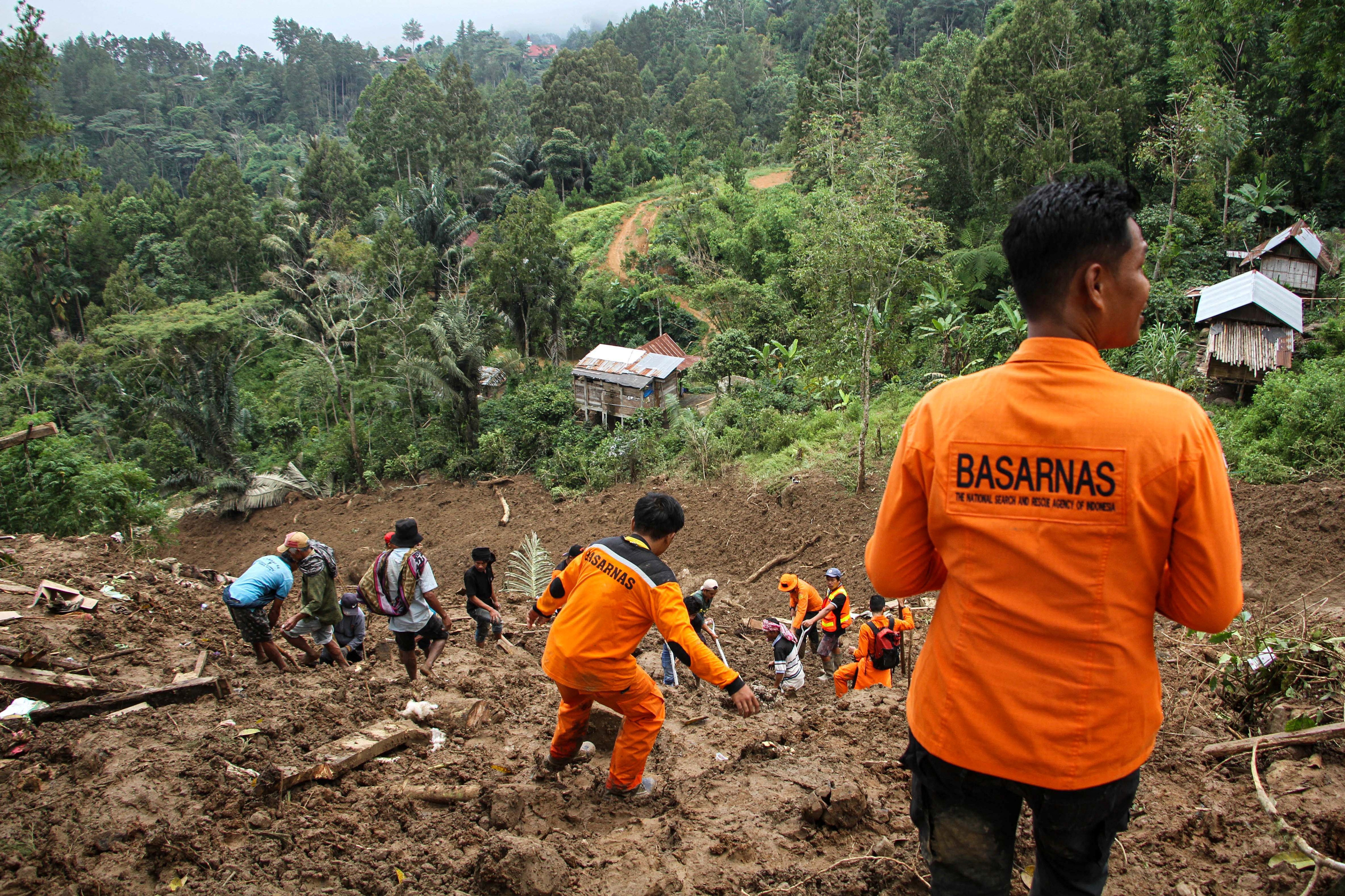Indonesian rescue members with residents evacuated people from the site of a landslide triggered by high-intensity rains, that affected two villages in Tana Toraja