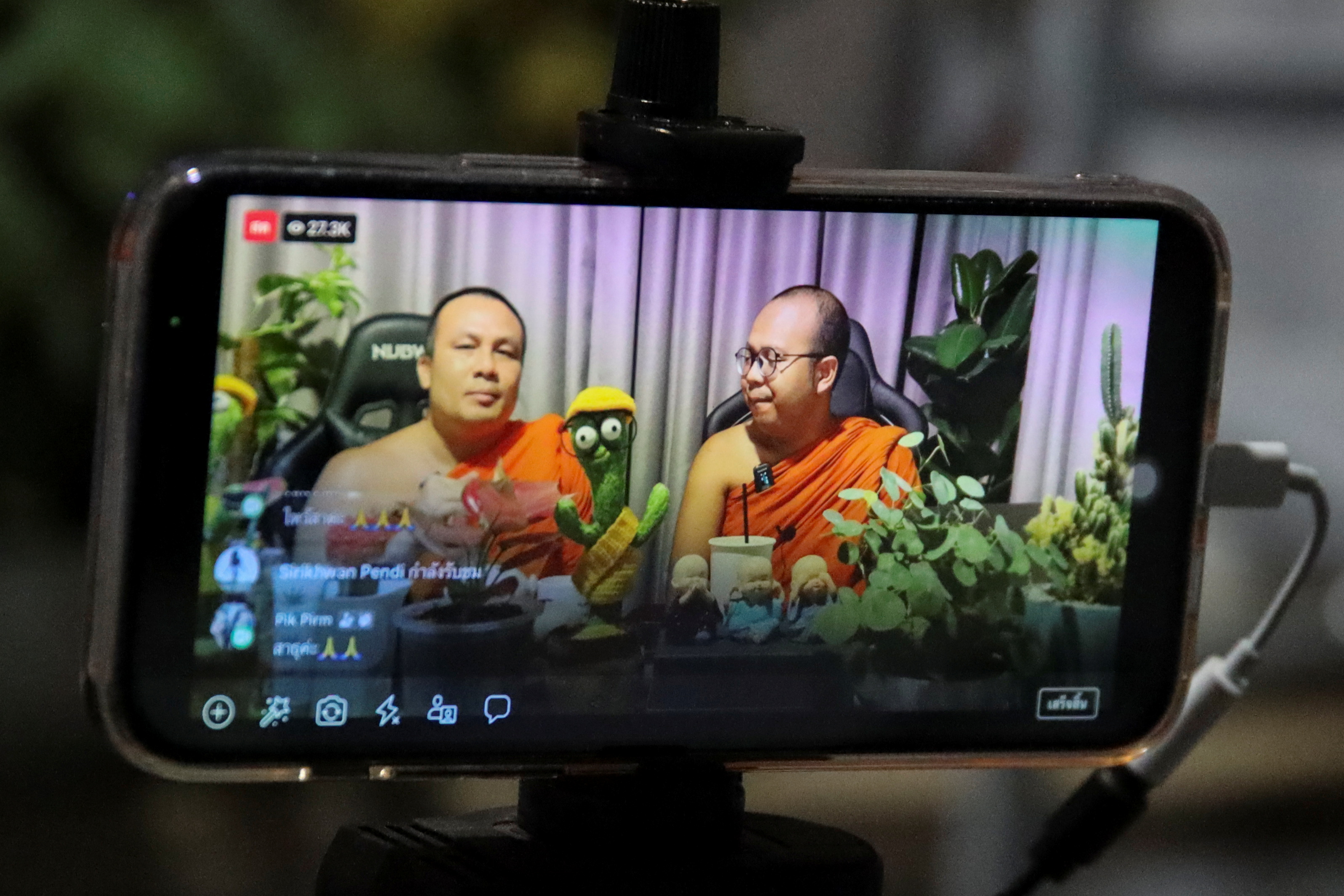 Buddhist monks host a chat show during a Facebook live at a temple in Bangkok