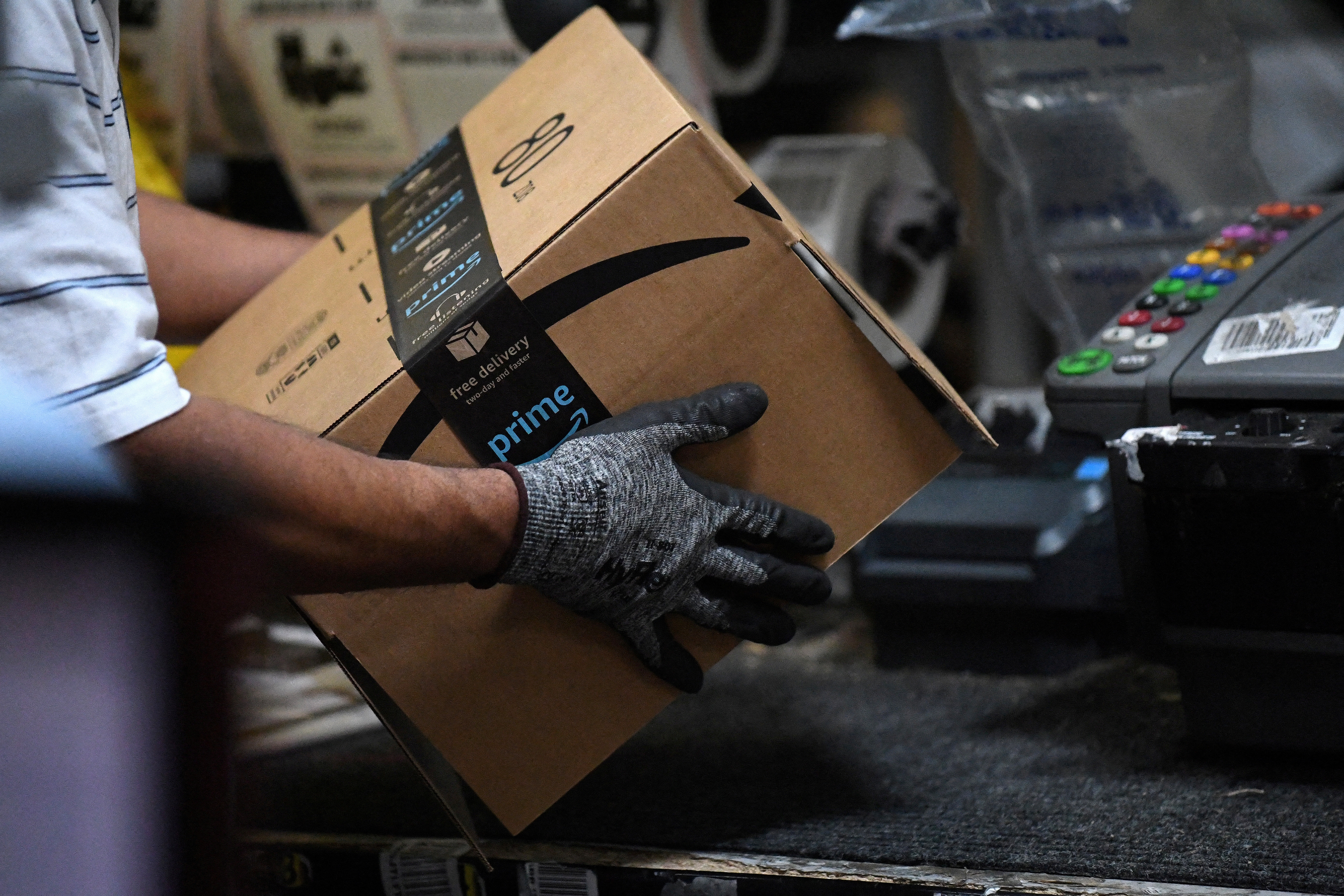 Worker assembles a box for delivery at the Amazon fulfilment center in Baltimore