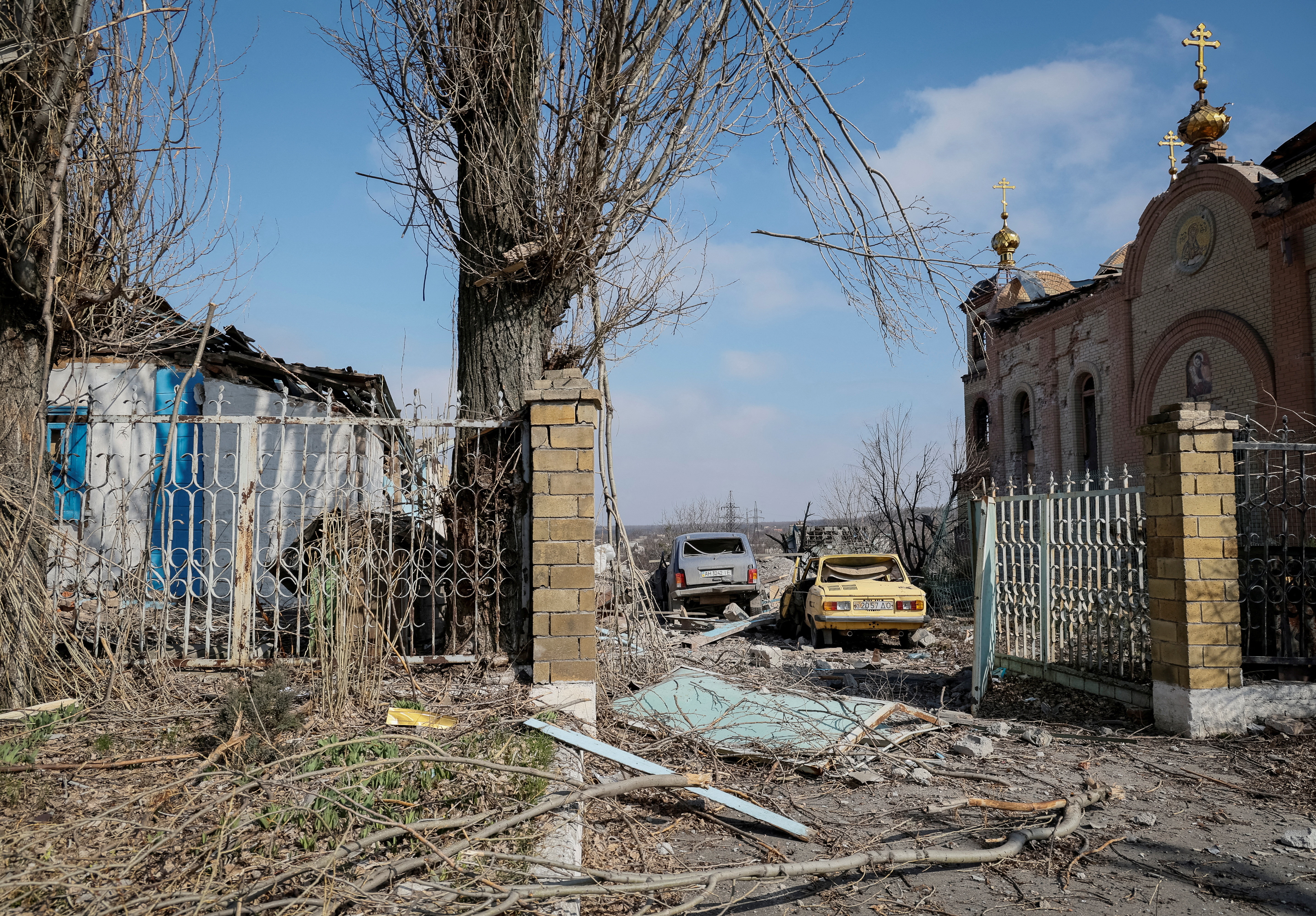 A view shows a residential building, cars and a church damaged by a Russian military strike in the frontline city of Avdiivka