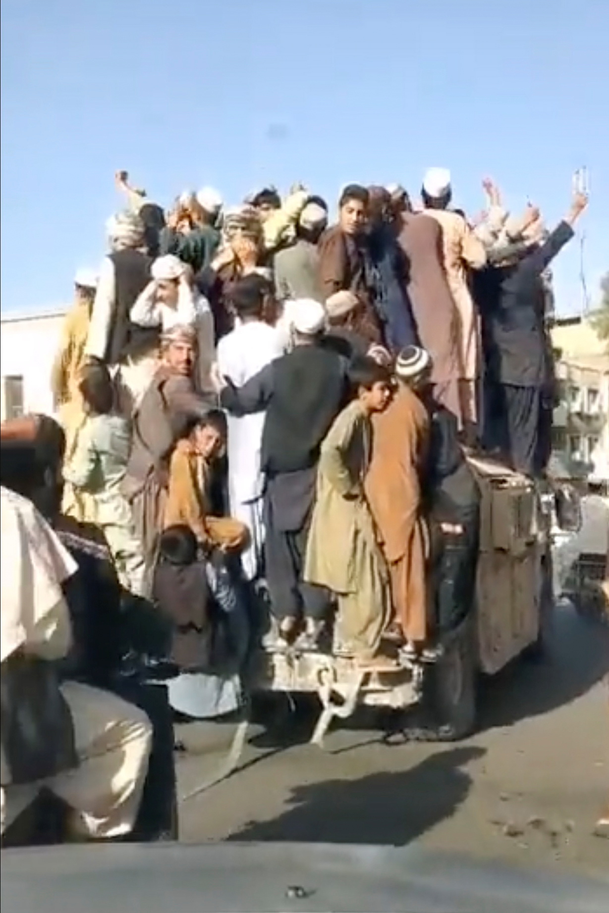 People standing atop an armored vehicle celebrate as it drives through Shaheedan Square, in the city of Kandahar, Afghanistan in this screen grab taken from a video from social media uploaded on August 13, 2021. TALIBAN HANDOUT/via REUTERS  THIS IMAGE HAS BEEN SUPPLIED BY A THIRD PARTY.