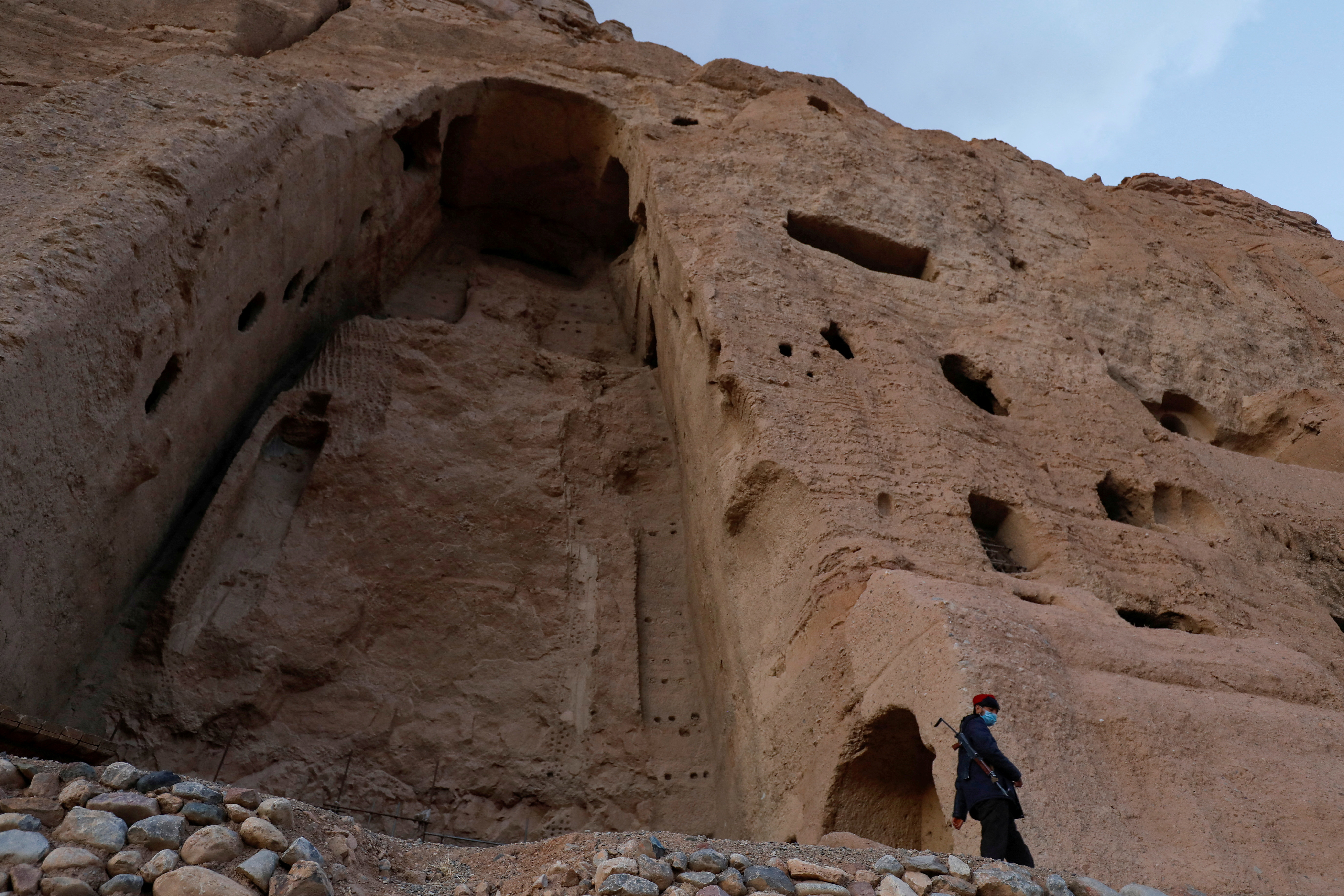A Taliban soldier stands guard in front of the ruins of a 1500-year-old Buddha statue in Bamyan