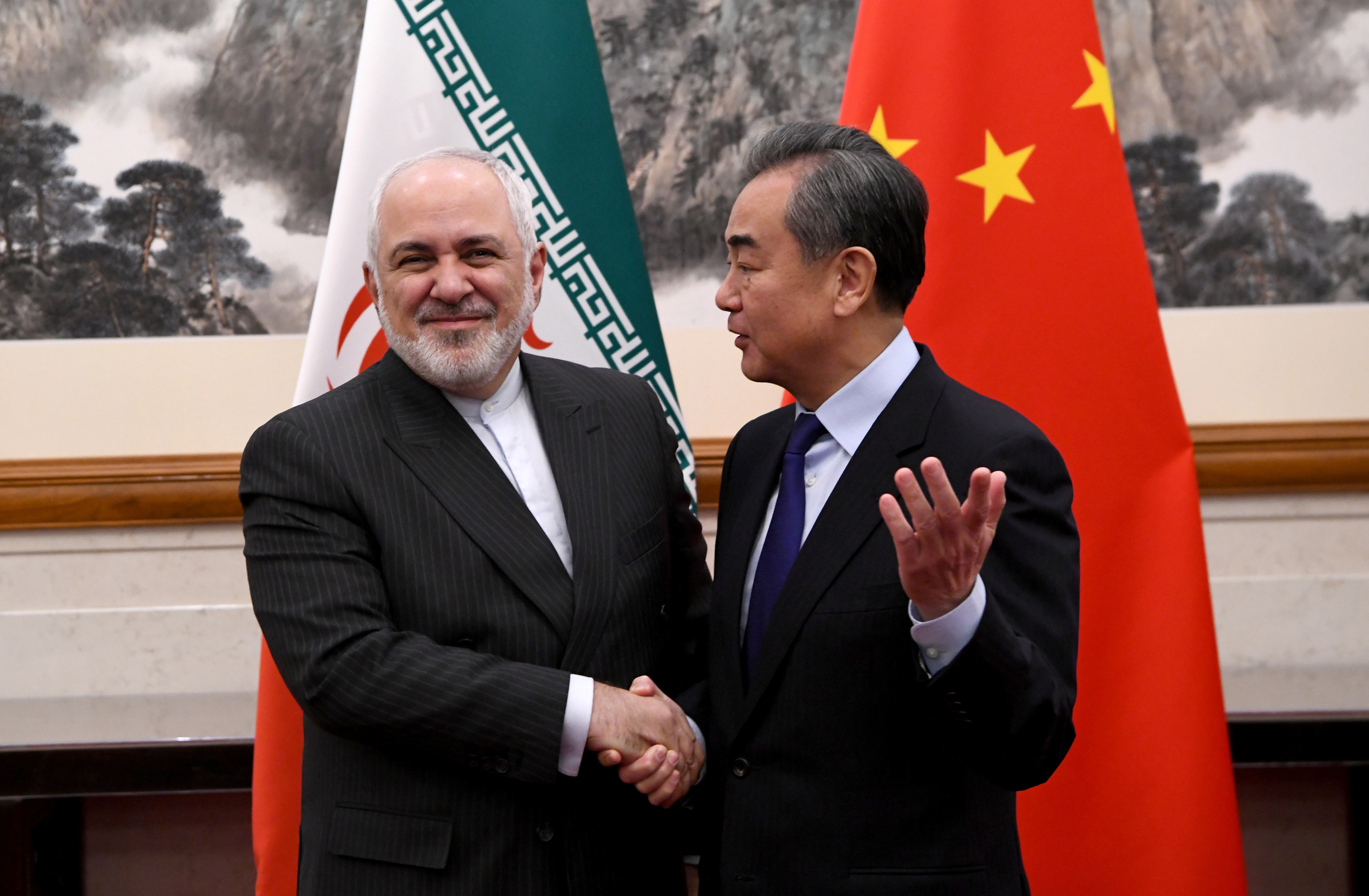 China's Foreign Minister Wang Yi shakes hands with Iran's Foreign Minister Mohammad Javad Zarif during a meeting at the Diaoyutai state guest house in Beijing