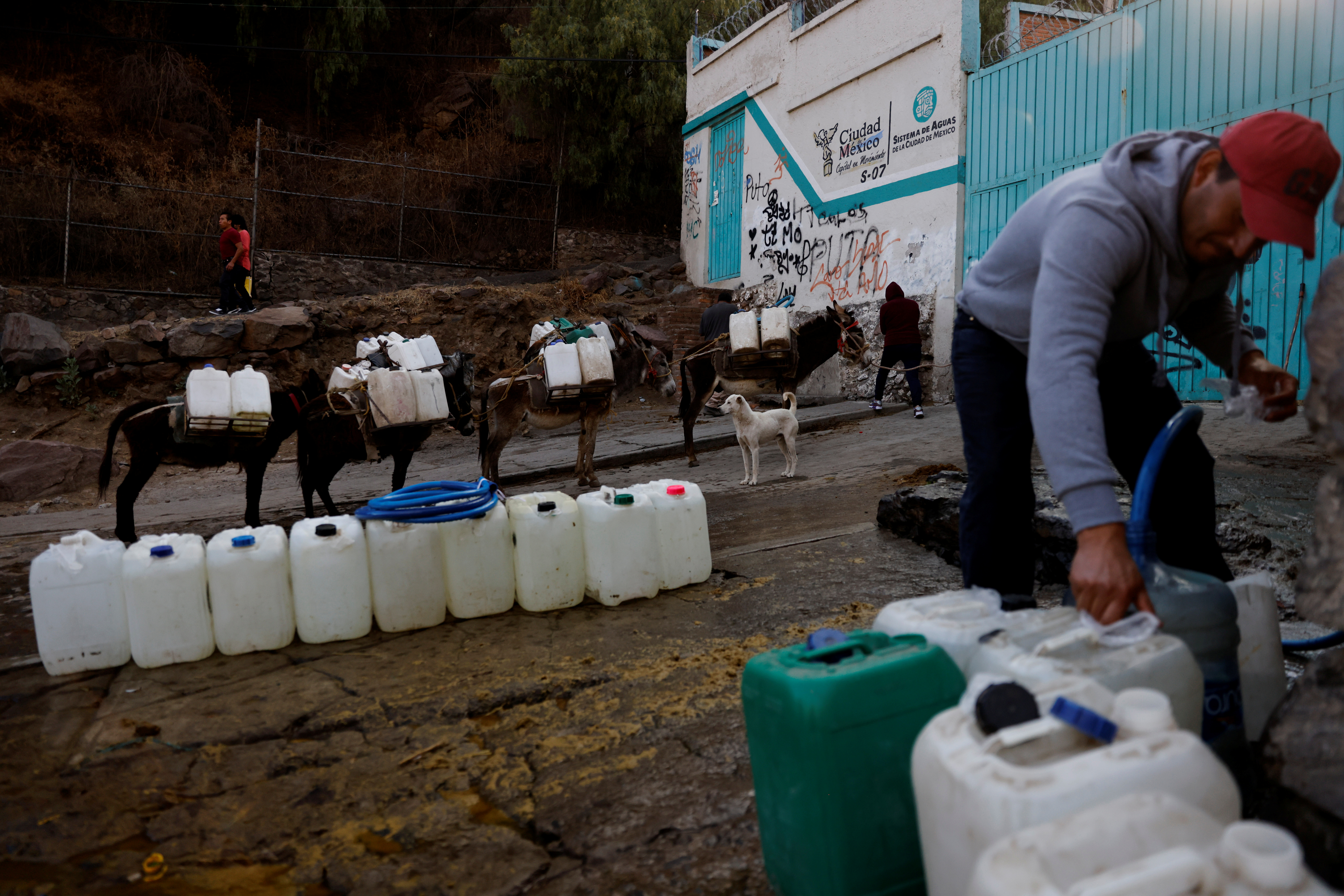 A resident fills water tanks with water for his use as Mexico City and the metropolitan area it is running out of water as drought takes hold of the city of almost 22 million people in the municipality of  Xochimilco in Mexico City, Mexico April 20, 2021. Picture taken April 20, 2021. REUTERS/Carlos Jasso