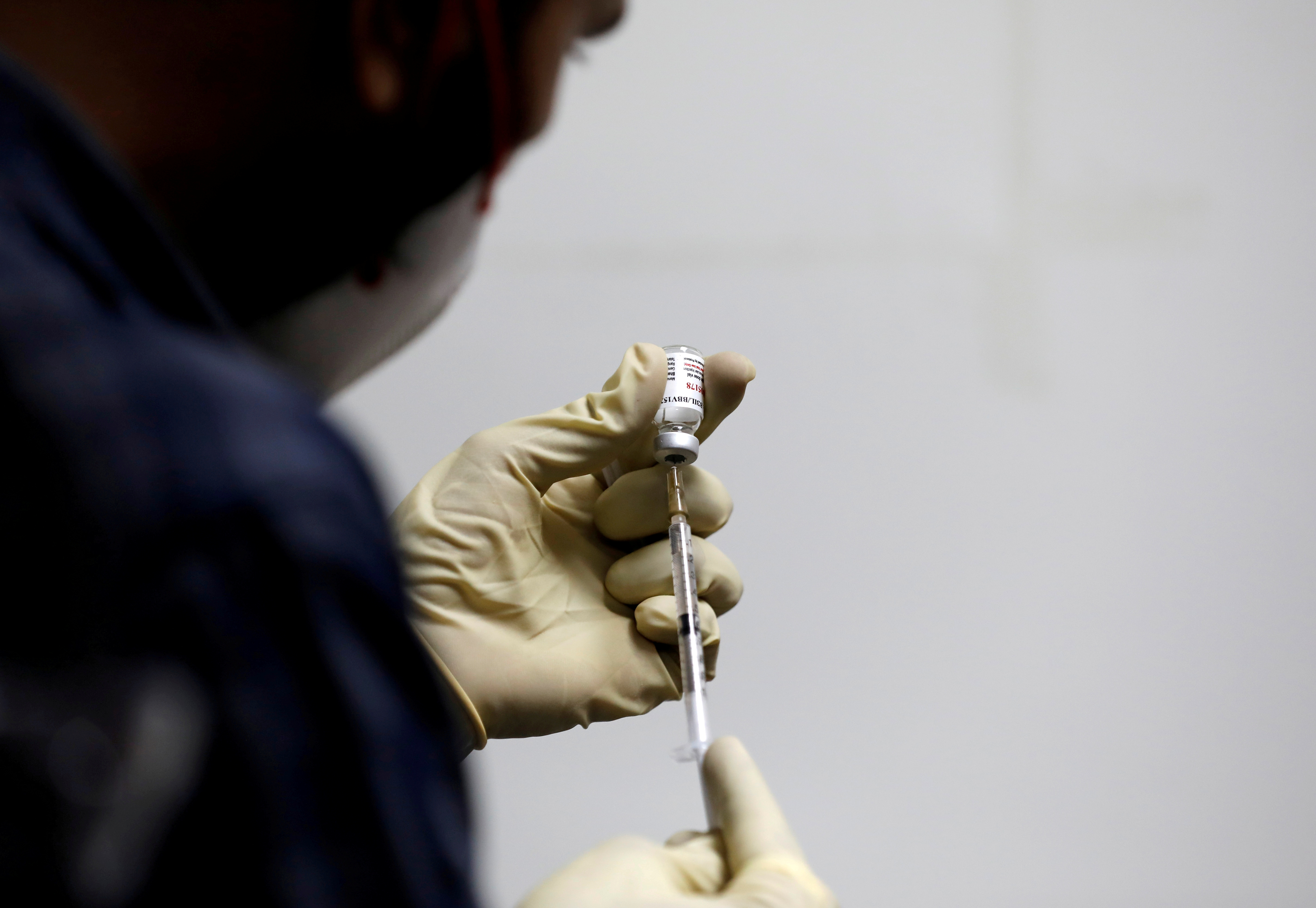 A medic fills a syringe with COVAXIN, an Indian government-backed experimental COVID-19 vaccine, before administering it to a health worker during its trials, in Ahmedabad