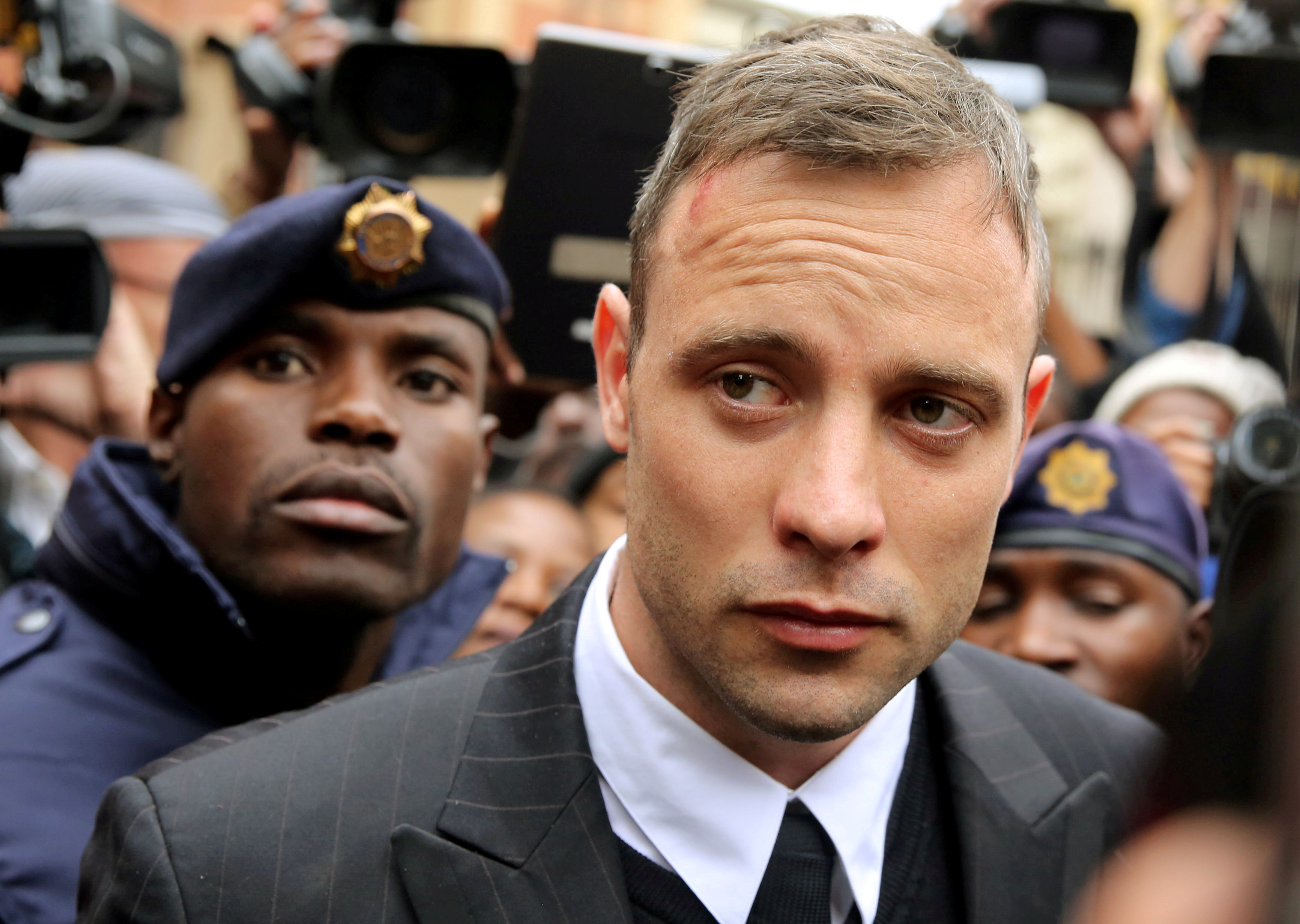Olympic and Paralympic track star Oscar Pistorius leaves court after appearing for the 2013 killing of his girlfriend Reeva Steenkamp