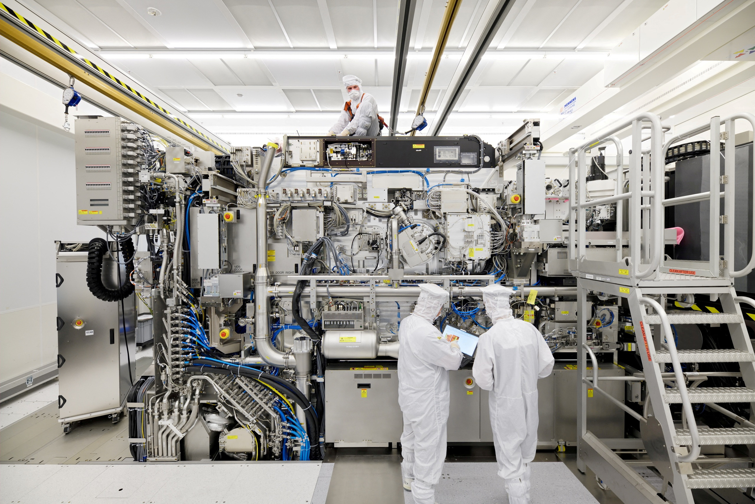 Employees are seen working on the final assembly of ASML's TWINSCAN NXE:3400B semiconductor lithography tool with its panels removed, in Veldhoven